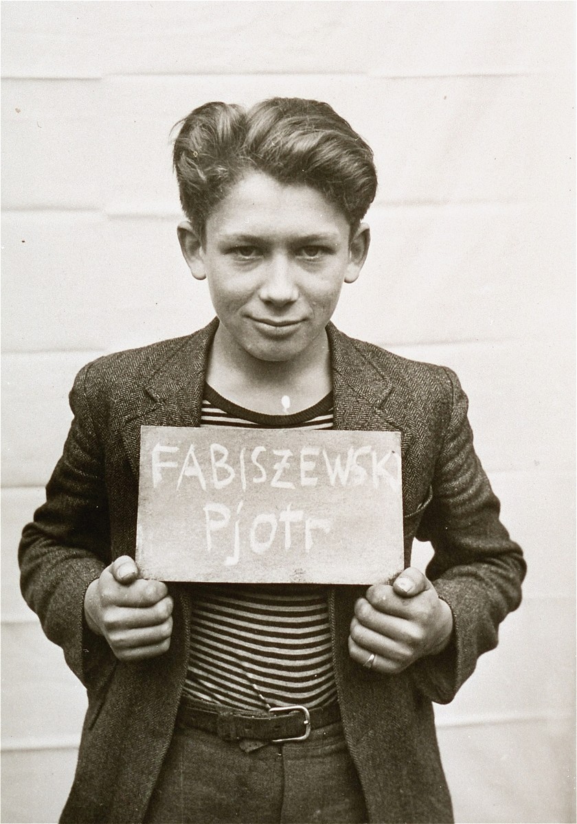 Pjotr Fabiszewski holds a name card intended to help any of his surviving family members locate him at the Kloster Indersdorf DP camp.  This photograph was published in newspapers to facilitate reuniting the family.