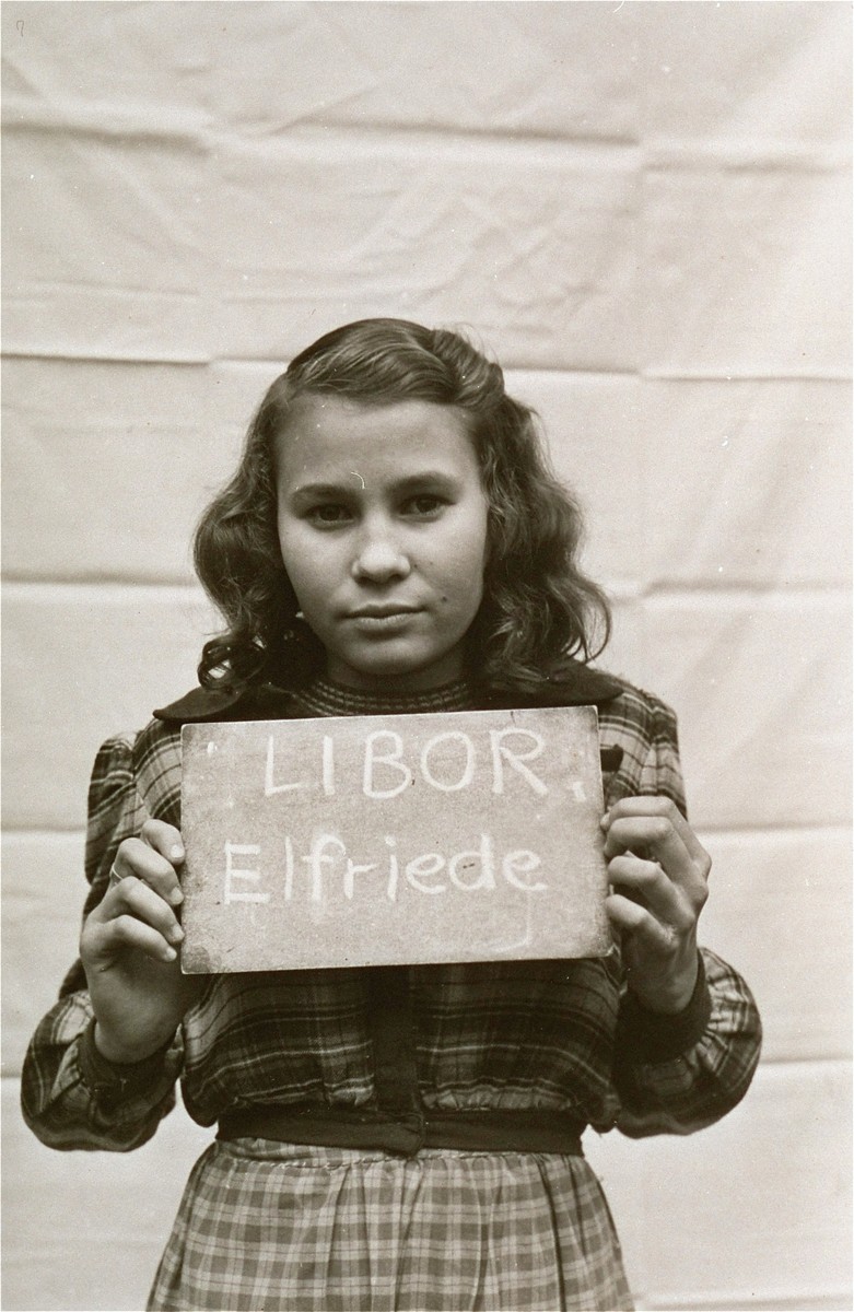 Elfriede Libor holds a name card intended to help any of her surviving family members locate her at the Kloster Indersdorf DP camp.  This photograph was published in newspapers to facilitate reuniting the family.