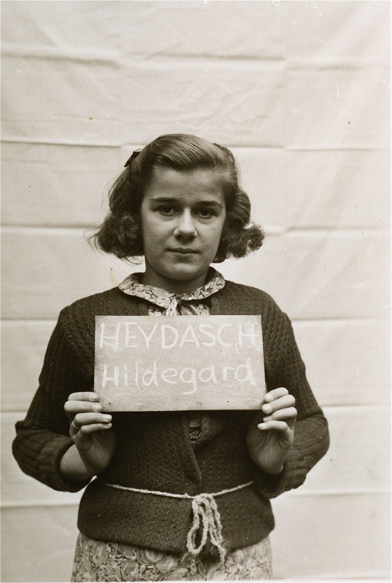 Hildegard Heydasch holds a name card intended to help any of her surviving family members locate her at the Kloster Indersdorf DP camp.  This photograph was published in newspapers to facilitate reuniting the family.