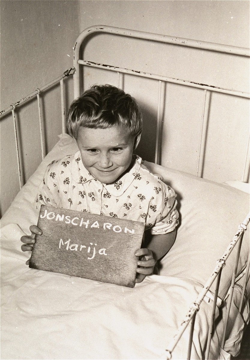 Marija Jonscharon holds a name card intended to help any of her surviving family members locate her at the Kloster Indersdorf DP camp.  This photograph was published in newspapers to facilitate reuniting the family.