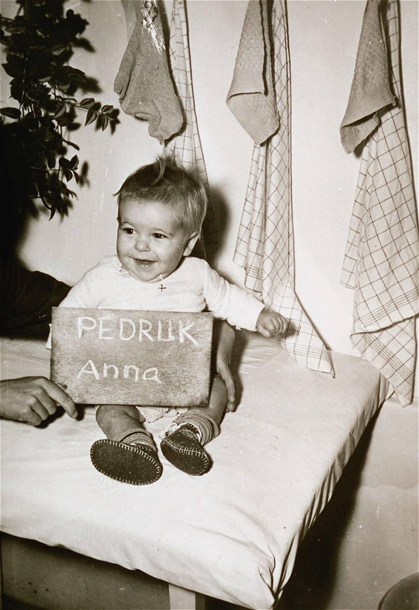 Infant Anna Pedruk with a name card intended to help any of her surviving family members locate her at the Kloster Indersdorf DP camp.  This photograph was published in newspapers to facilitate reuniting the family.
