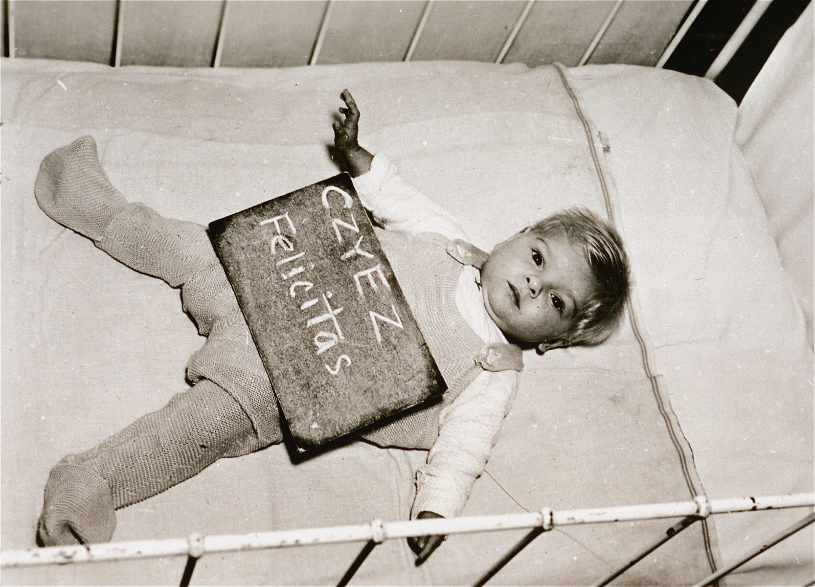 Infant Felicitas Czyez with a name card intended to help any of her surviving family members locate her at the Kloster Indersdorf DP camp.  This photograph was published in newspapers to facilitate reuniting the family.