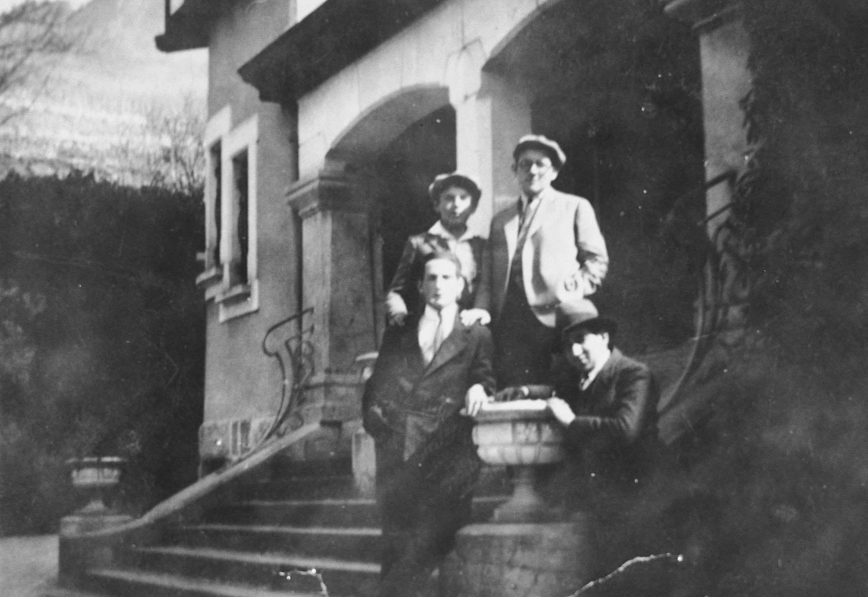 Four young men pose on the steps outside their yeshiva.