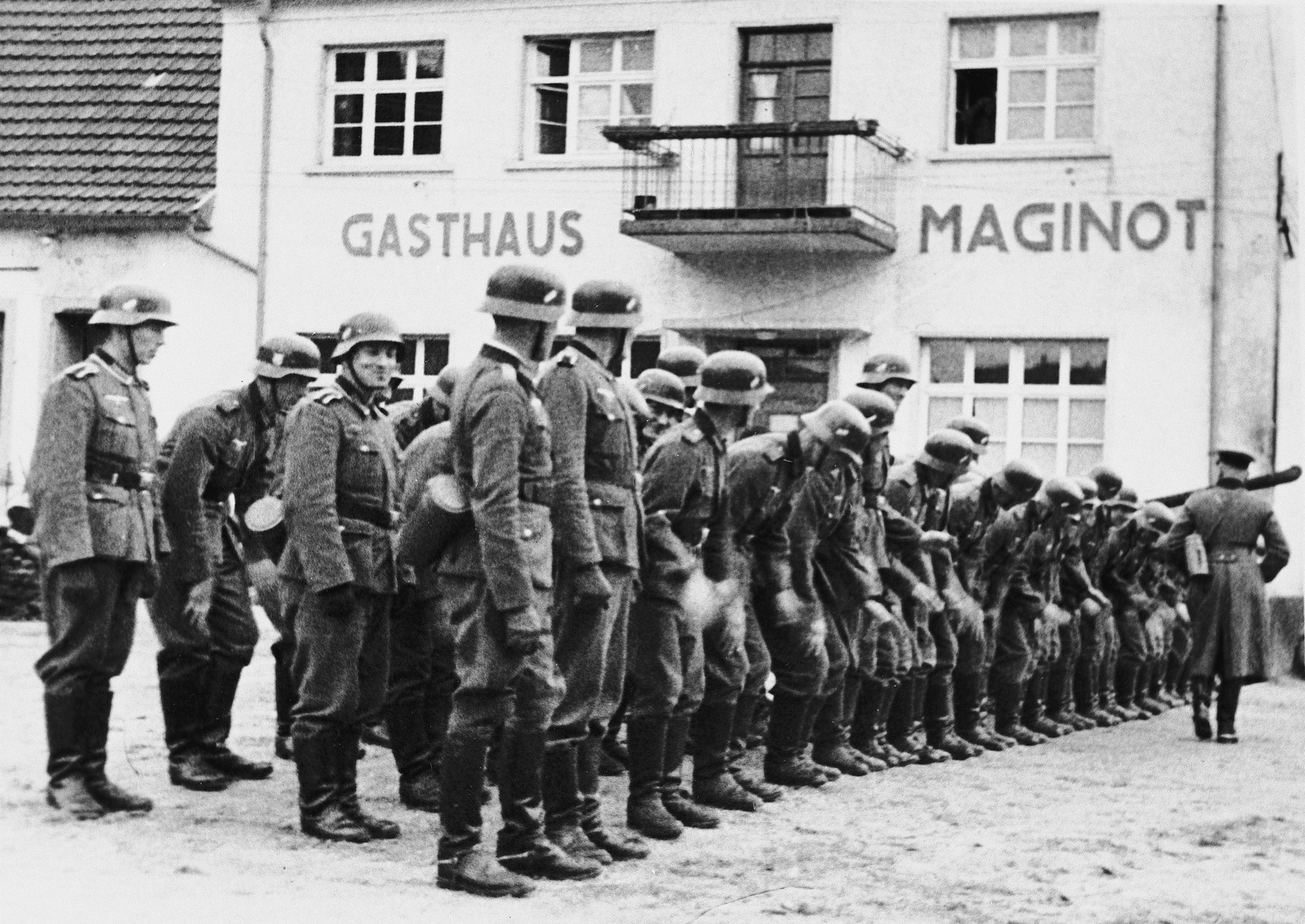 A German officer inspects his troops in front of the Gasthaus Maginot in Eppenbrunn, Germany.