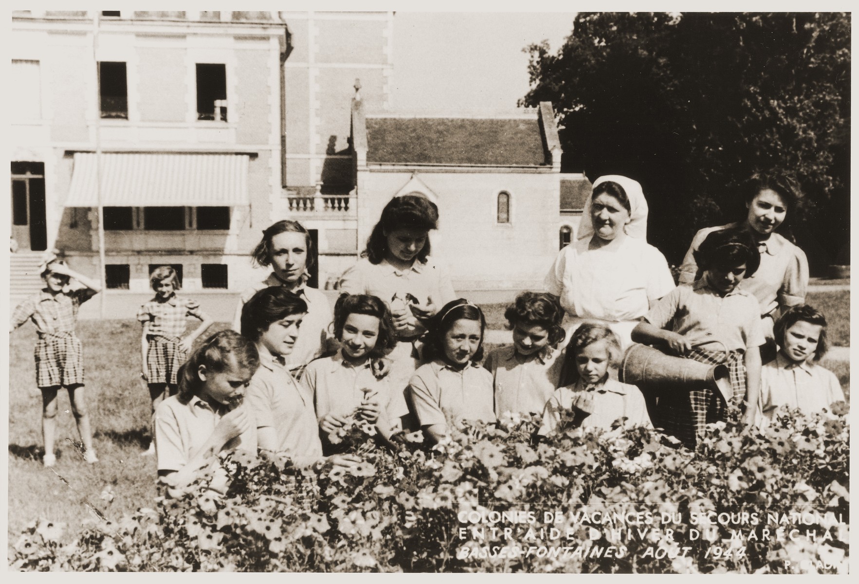 Group portrait of girls in the garden of the Les Basses-Fontaines children's home, where Jewish children were hidden during the war.  

Among those pictured (with their aliases) are Eva Tuchsznajder (Yvonne Drapier) and France Cohen (Colin).  The caption identifies Les Basses-Fontaines as a vacation home sponsored by Petain.