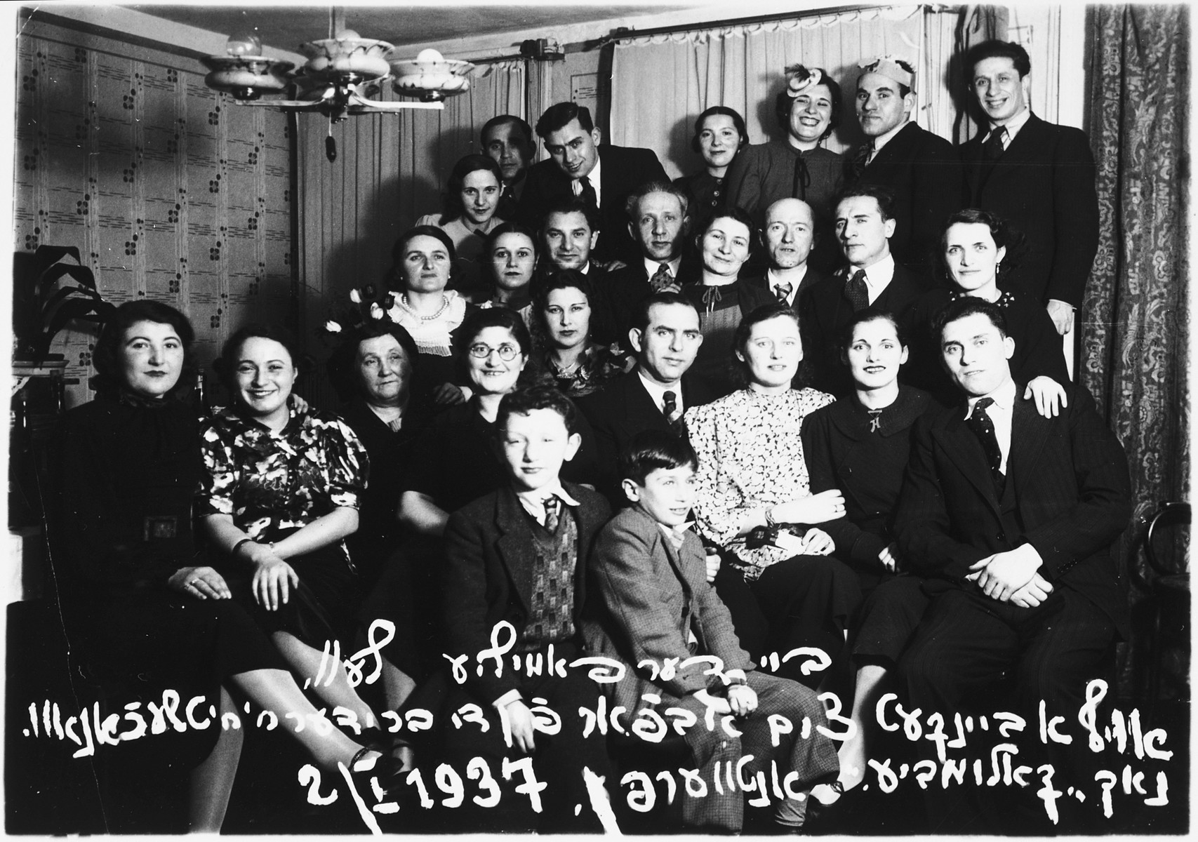 Group portrait of family and friends attending a banquet to mark the departure of the Ciechanow brothers, Alex and Adolf, for Colombia.

Among those pictured is Alex Ciechanow (bottom, right), Leah Ciechanow (behind Alex), Rochelle Ciechanow (front row, third from the right), Monek Lublin (front row, fourth from the right), Jackie Ciechanow (boy in the front row, center), Mendel Olszyn (second row from the top, center).  Also pictured are Estera and Adolf Ciechanow and Chana (Ciechanow) Olszyn.