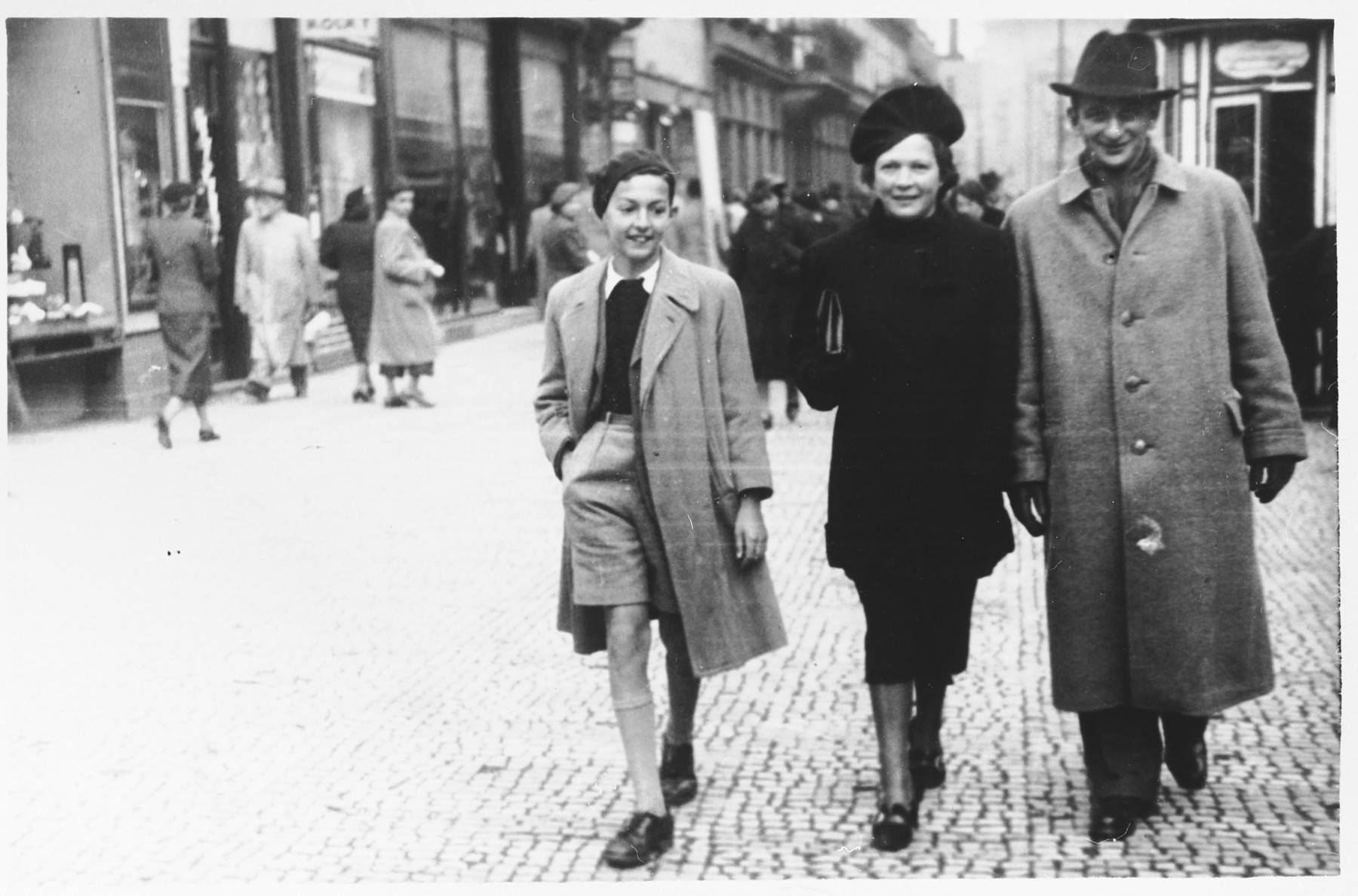 Austrian Jewish refugees walk along a street in Prague.

Pictured from left to right are Alfred and Trimette Langer.  The man on the right is unidentified.