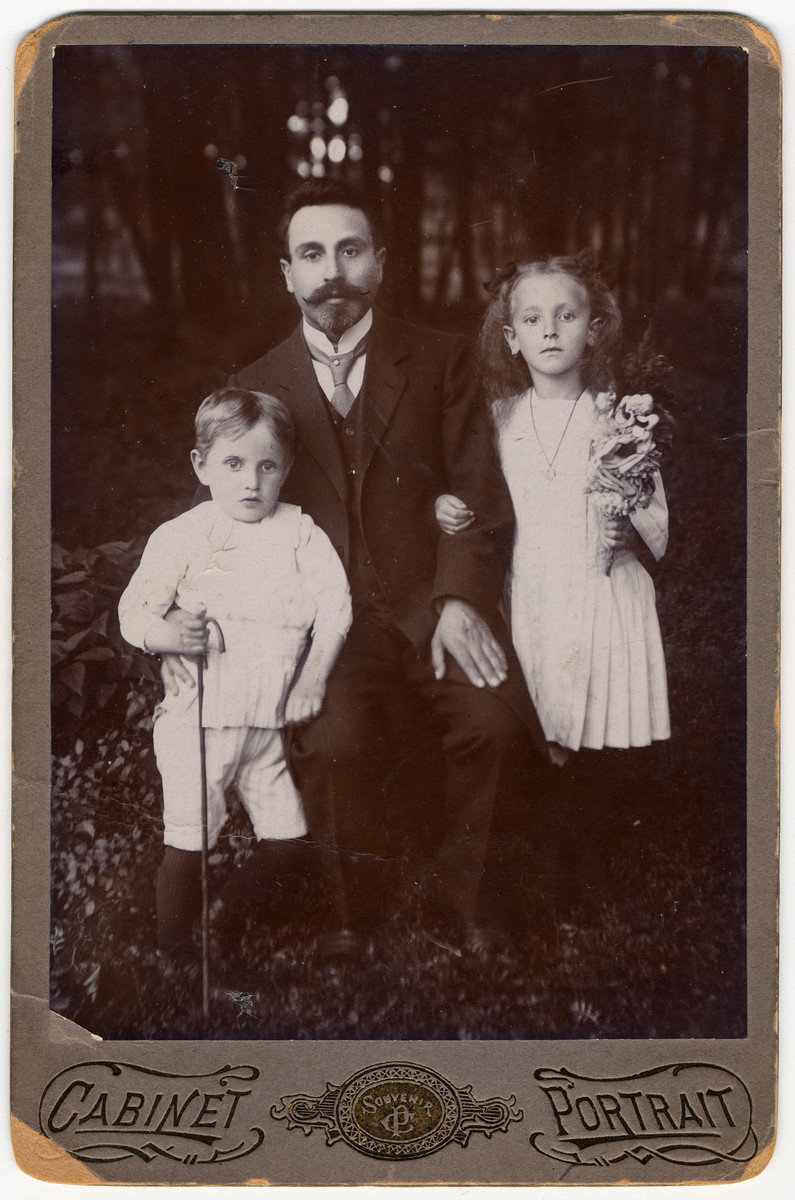 Studio portrait of a Polish Jewish family sent to a relative as a Jewish New Year's card.

Pictured are Velvel Suchowolsky and his children David and Nechama.