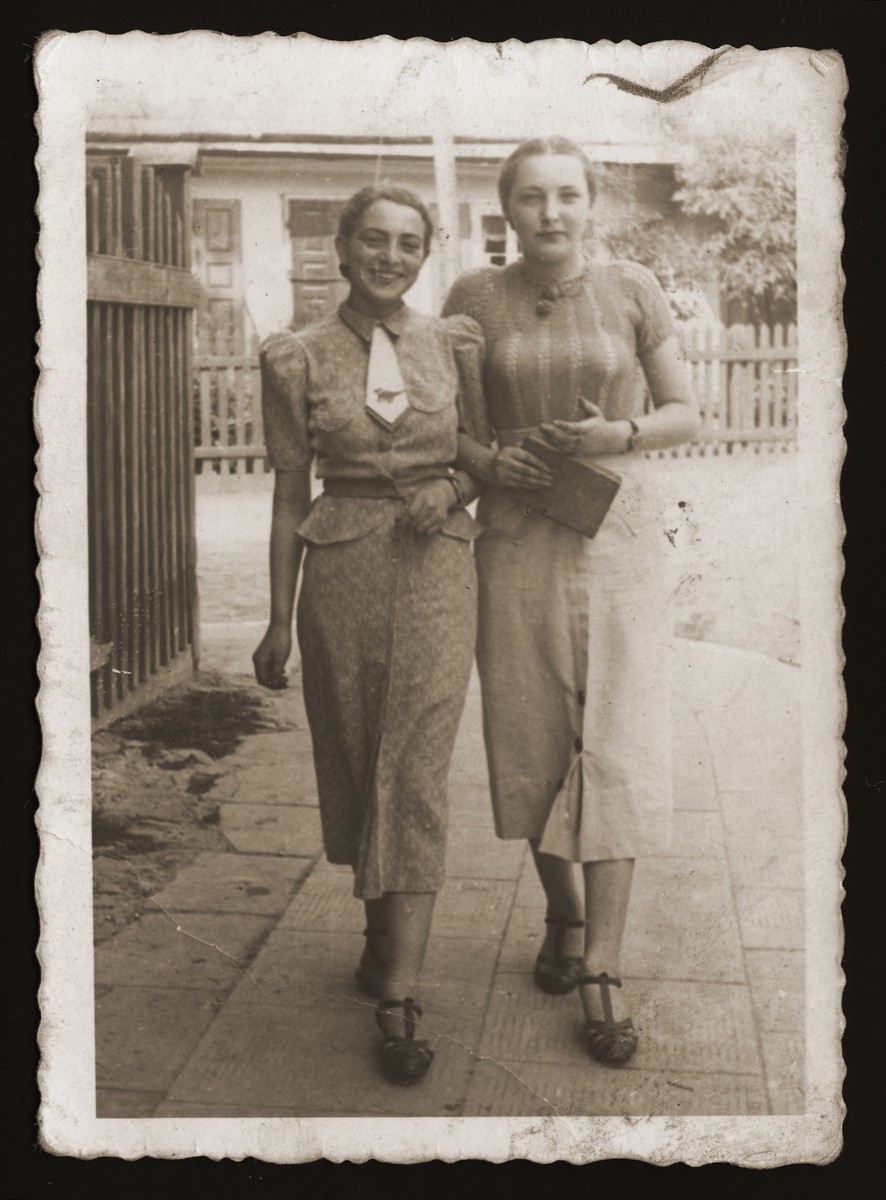 Two young Jewish women walk along a street in Chelm.

Pictured are Estera Ajzen (left) and her friend, Esterka Fiszbajn (right).