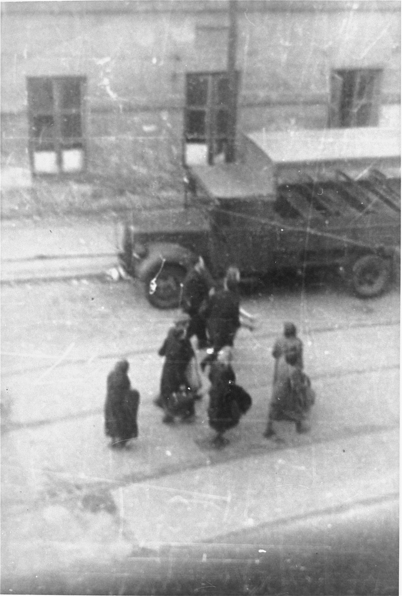 Jews captured by the SS during the suppression of the Warsaw ghetto uprising march past the St. Zofia hospital down Nowolipie Street towards the Umschlagplatz for deportation.