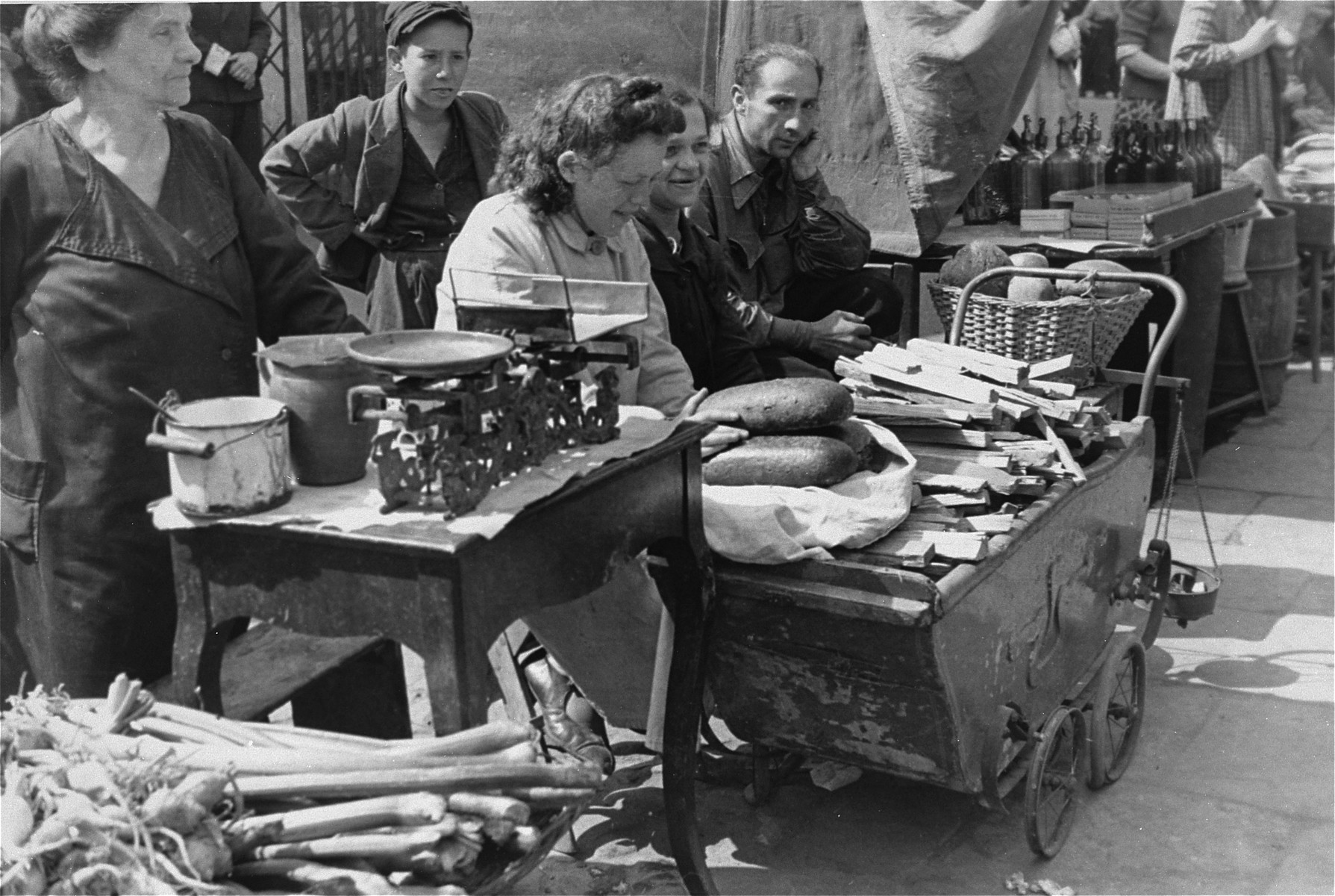 Street vendors in the Warsaw ghetto offer bread and kindling for sale.