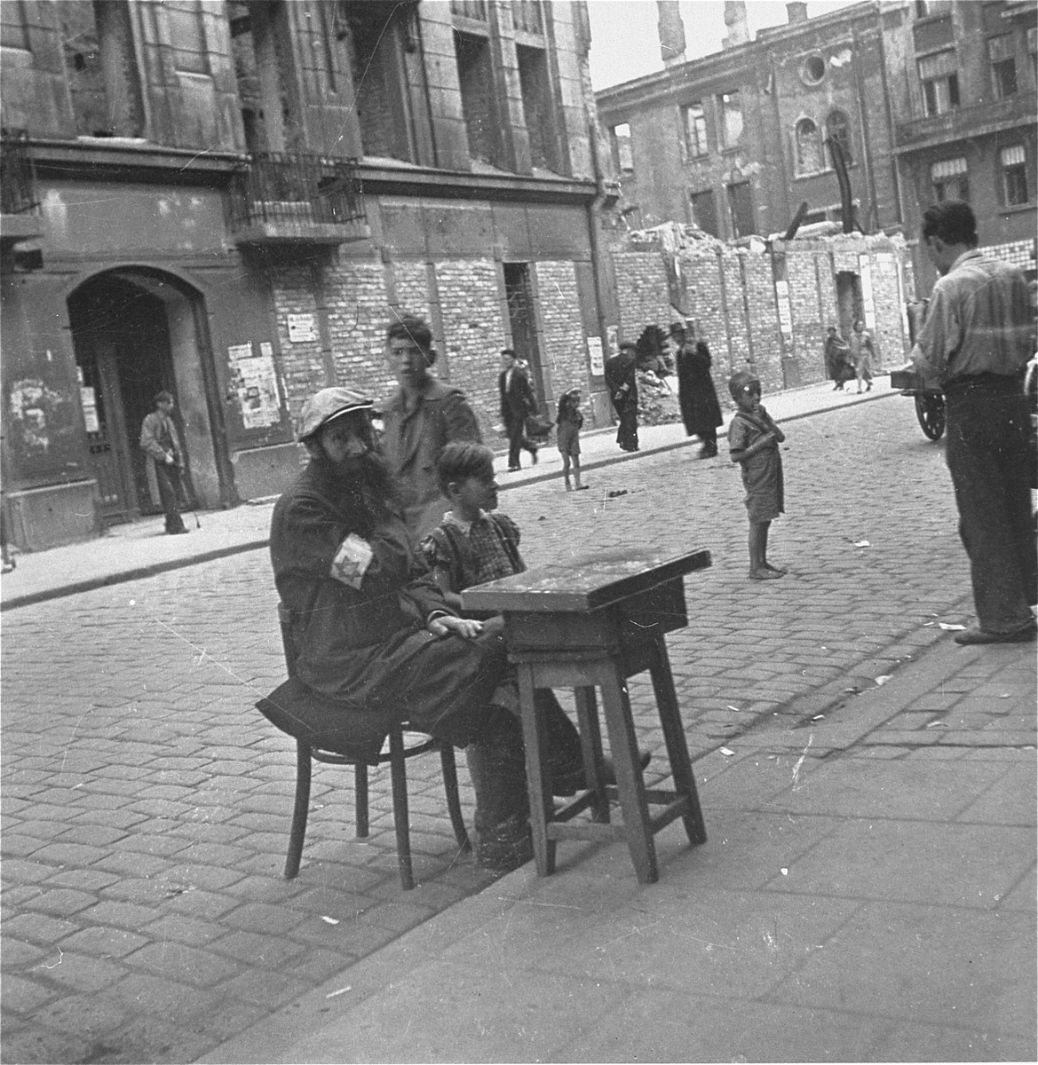 A vendor on the street in the Warsaw ghetto.  

Joest's original caption reads: "This man was selling something.  I don't know more [about it], was it cigarettes?  The fact that small boy was barefoot on this September day again stood out to me."