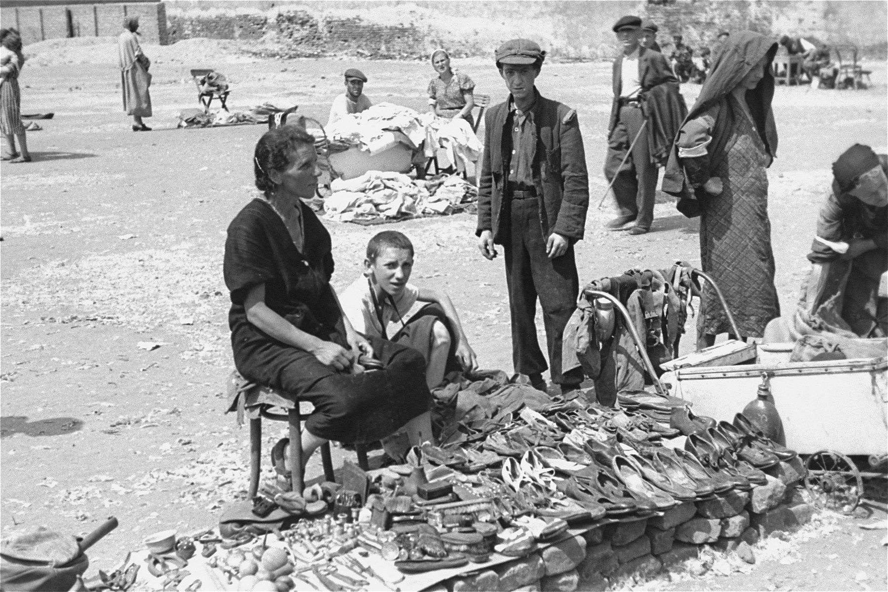 Vendors sell old shoes and other items of used clothing at an open air market in the Warsaw ghetto.