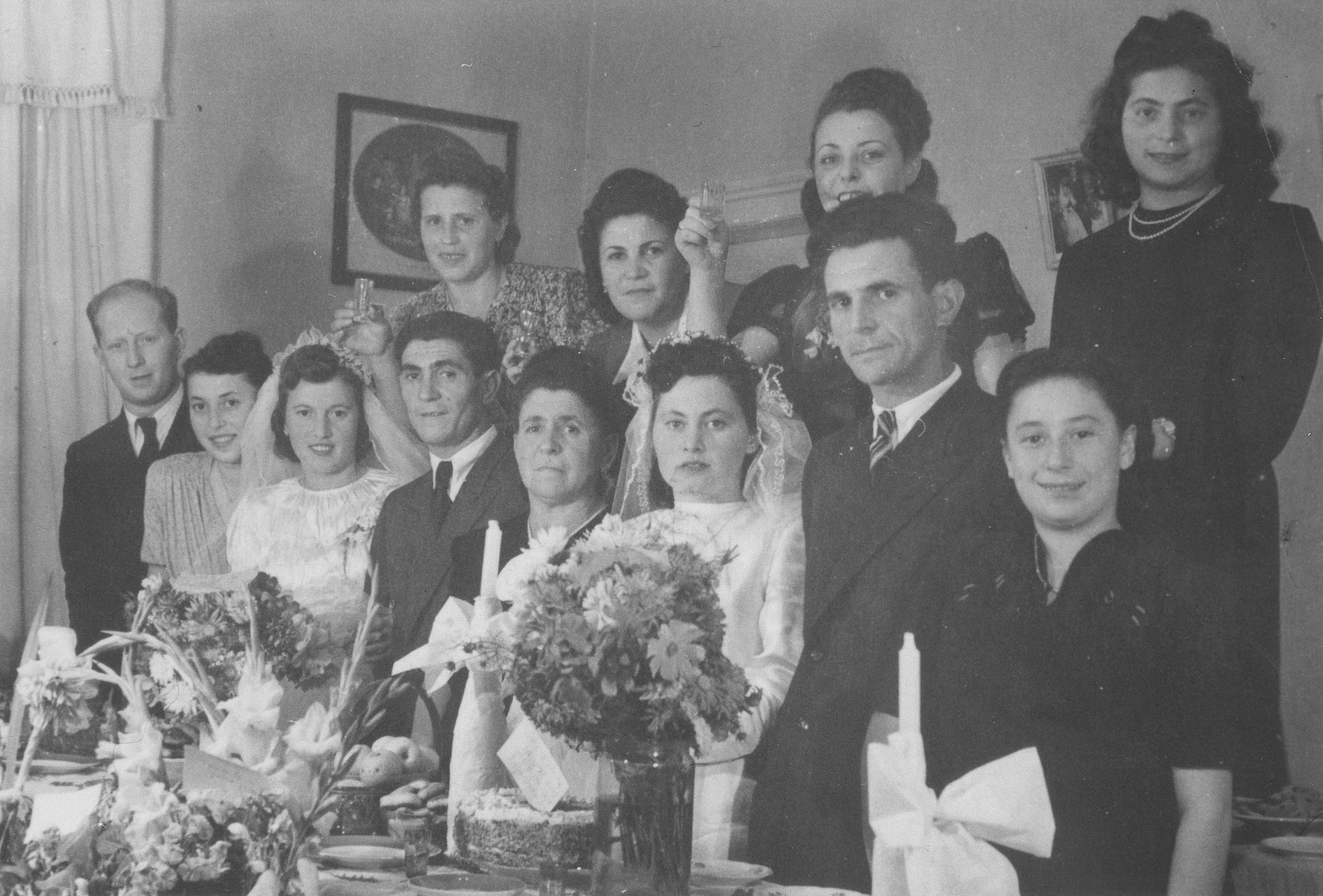 Family and friends celebrate the double wedding of Israel and Zlata (Distel) Malcmacher and Motel and Lola (Rolnik) Malcmacher.

Pictured from left to right are: (front row) Srulek and Natke (Rolnik) Katzman; Lola and Motel Malcmacher; Chaja Sara Malcmacher; Israel and Zlata Malcmacher; and Nechame (Probe) Rothschild; (back row): Chele (Huberman) Malcmacher; Rushke (Malcmacher) Borenstein; Sabina (Warshawsky) Rosenzweig; and Hadassah (Abramovich) Wandersman.