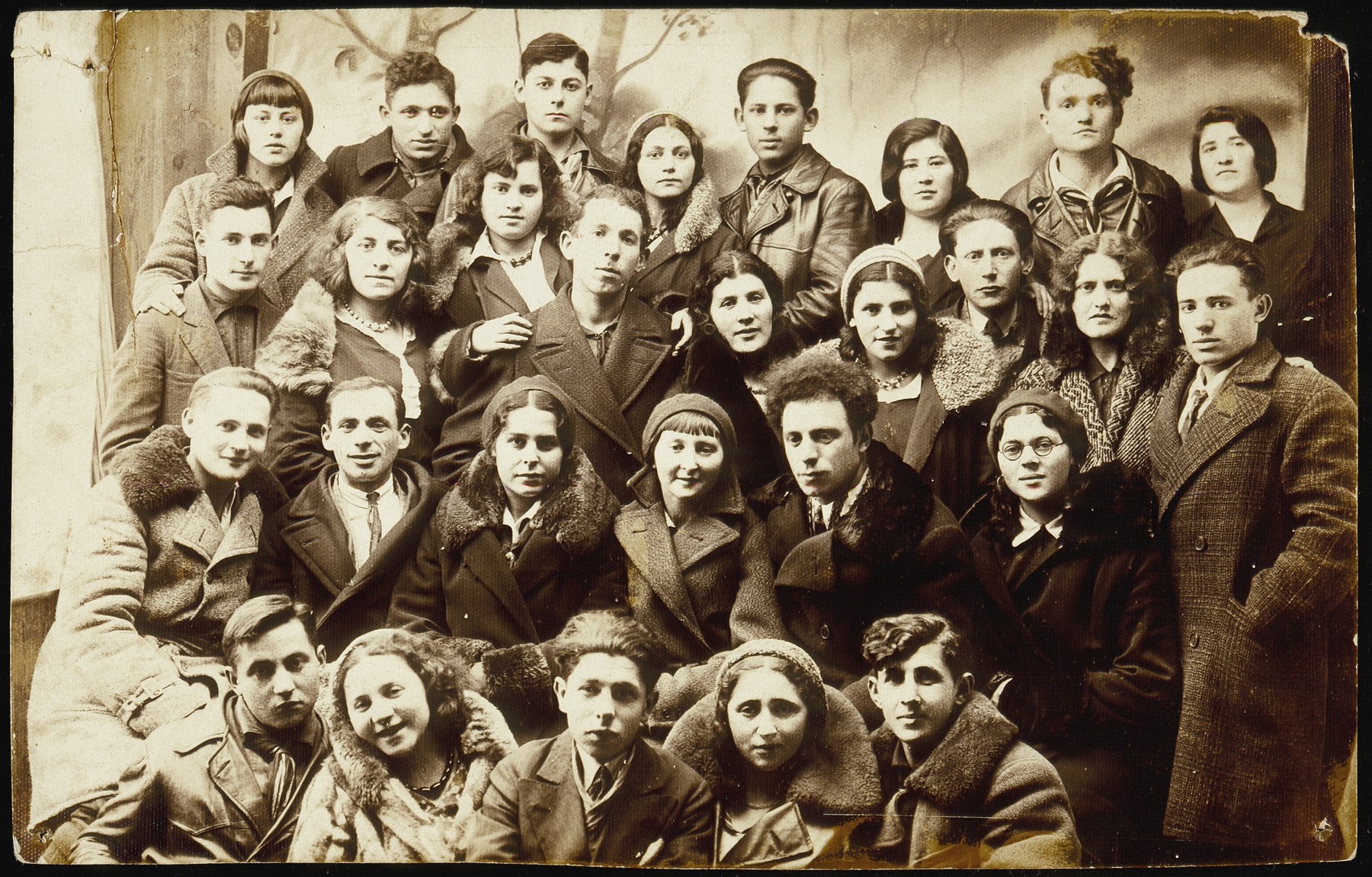 Group portrait of members of the Zionist youth movement, Hashomer Hatzair, from Eisiskes and surrounding towns.  
  
Among those pictured are: back row, right to left: Hinde Gutlevski, visitor, Reshke Gutlevski, visitor, Kreinke Bichwid, Muni Zahavi, Bichwid (sister of Kreinke); second row from the top, right to left:  Motke Burstein, Flora Kagan, Shmuel Berkowicz, unknown, Matikanski, unknown, Bichwid (first name unknown), Rina Lewinson, Hanan Polaczek; third row from the top, right to left: Etele Lubetski, visitor, Esther Katz Resnik, Miriam Koppelman Ruskin, Hayyim Streletski, unknown; front row, right to left: visitor from Olkeniki, Bavale Polaczek, visitor, Leipke Politacki, visitor.  

Muni Zahavi, Rina Lewinson, Shmuel Berkowicz, and Bavale Polaczek immigrated to Palestine. Feige (Flora) Kagan and Esther Katz Resnik also survived. All the others are believed to have ben murdered during the Holocaust.