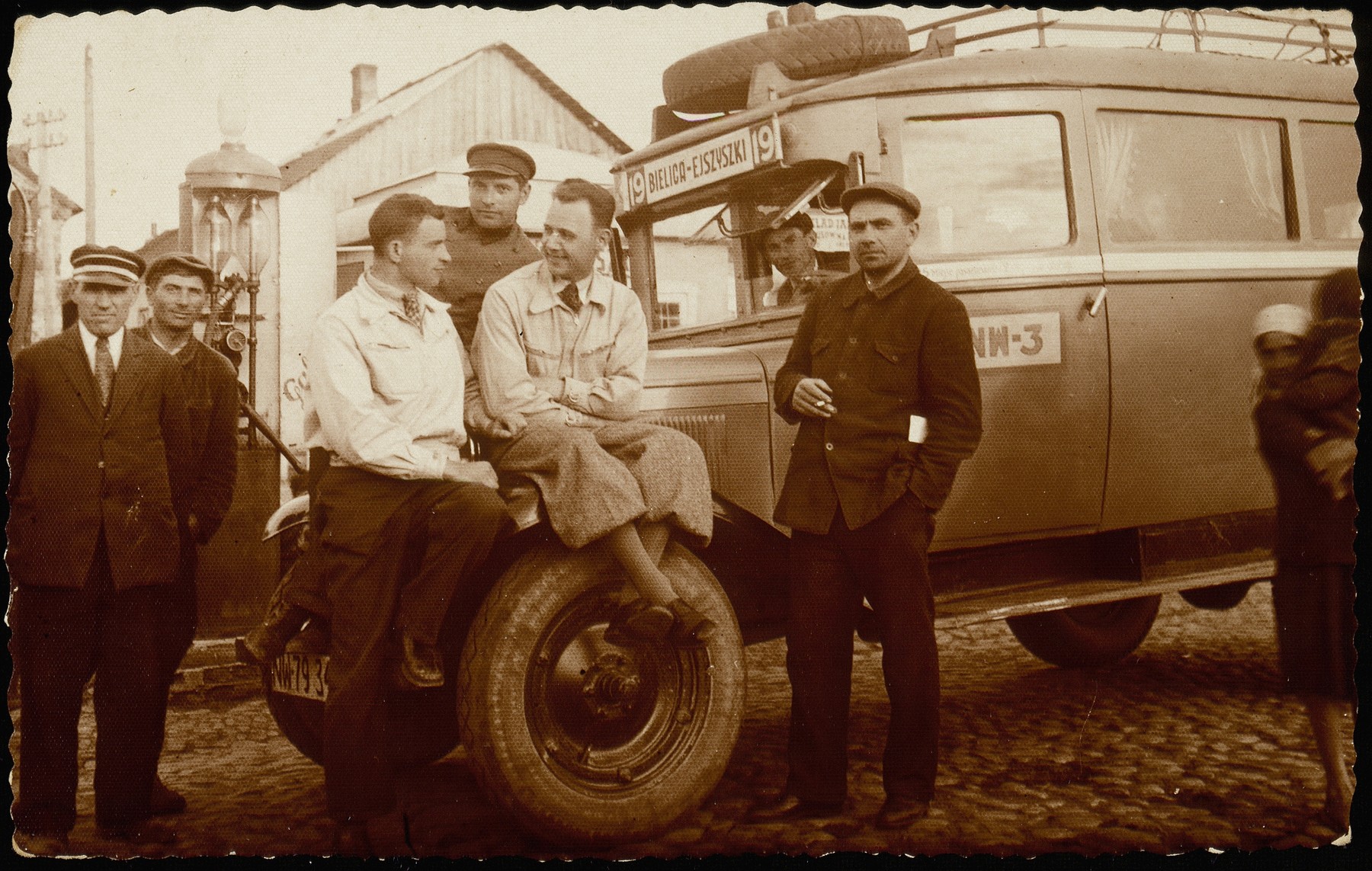 A group of men gather by the Bielica-Ejszyszki bus to Lida at the shtetl bus-stop and gasoline pump. 

(Right  to left)  Moshe Slonimski, in the driver's seat is Israel Erlich, between the two Polish drivers is Yankele Krisilov, the shtetl bus driver, Avraham Asner (uncle of Ed Asner), in front of the gasoline pump and Yankele Krisilov, who survived in Russia.  The others were murdered by the Germans and the AK.