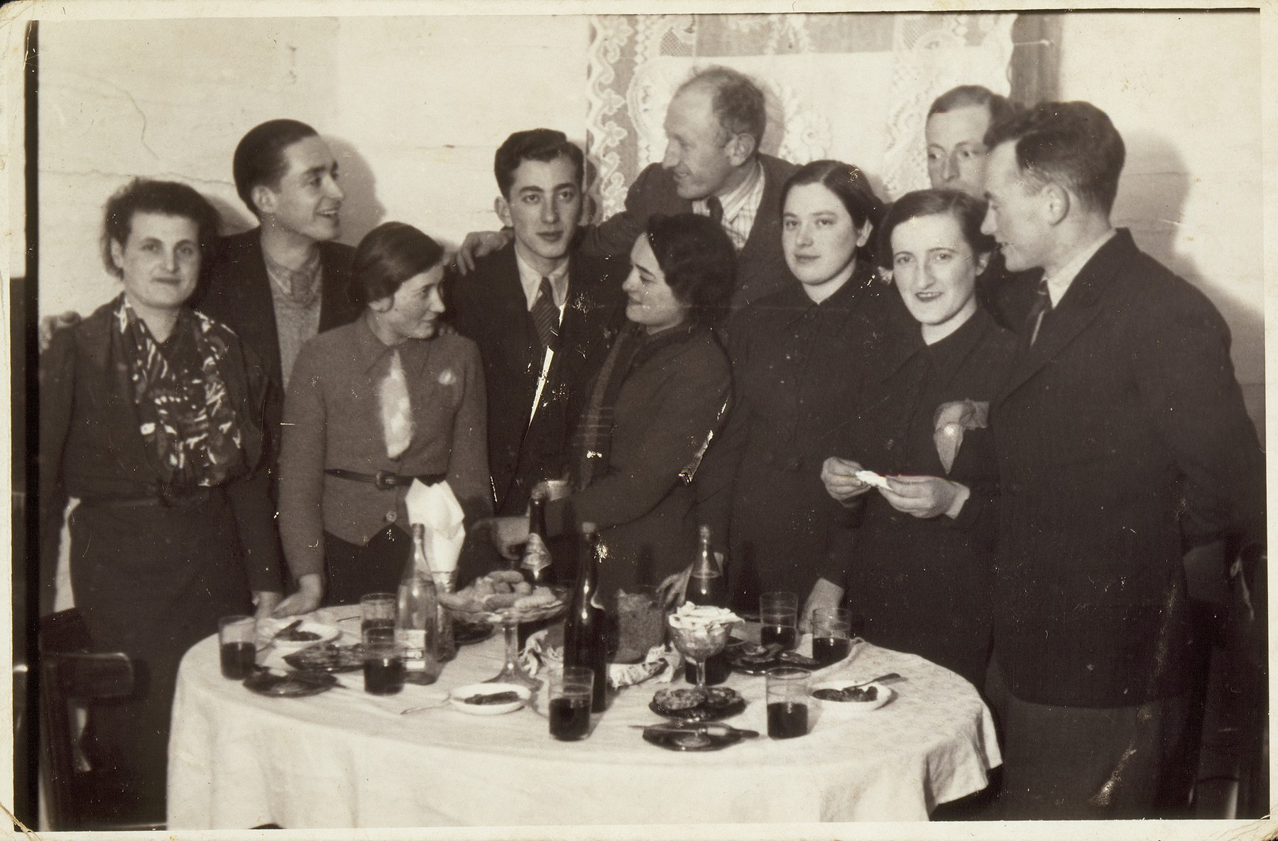 A Saturday night party at the home of Dina Weidenberg.

(right to left)  David Leib Levin; Miriam Kabacznik; her brother Shepske (in the back); Dina Weidenberg, Yehiel Blacharowicz; Kreinele Kanichowski; Dov Wolotzki;  Frumele Abelov, also a successful shopkeeper; an unidentified visitor; and Sarah Lejbowicz, sister of photographer Rephael. 

David-Leib survived the war in the forest, and Miriam and Shepske in hiding.  Dov was liberated from Dachau.  Kreinele was killed by members of the AK, including Pietka Barteszewicz, the caretaker of the Polish school where Kreinele once studied. All the others were killed by the Germans during the September 1941 mass shooting action in Eisiskes.
