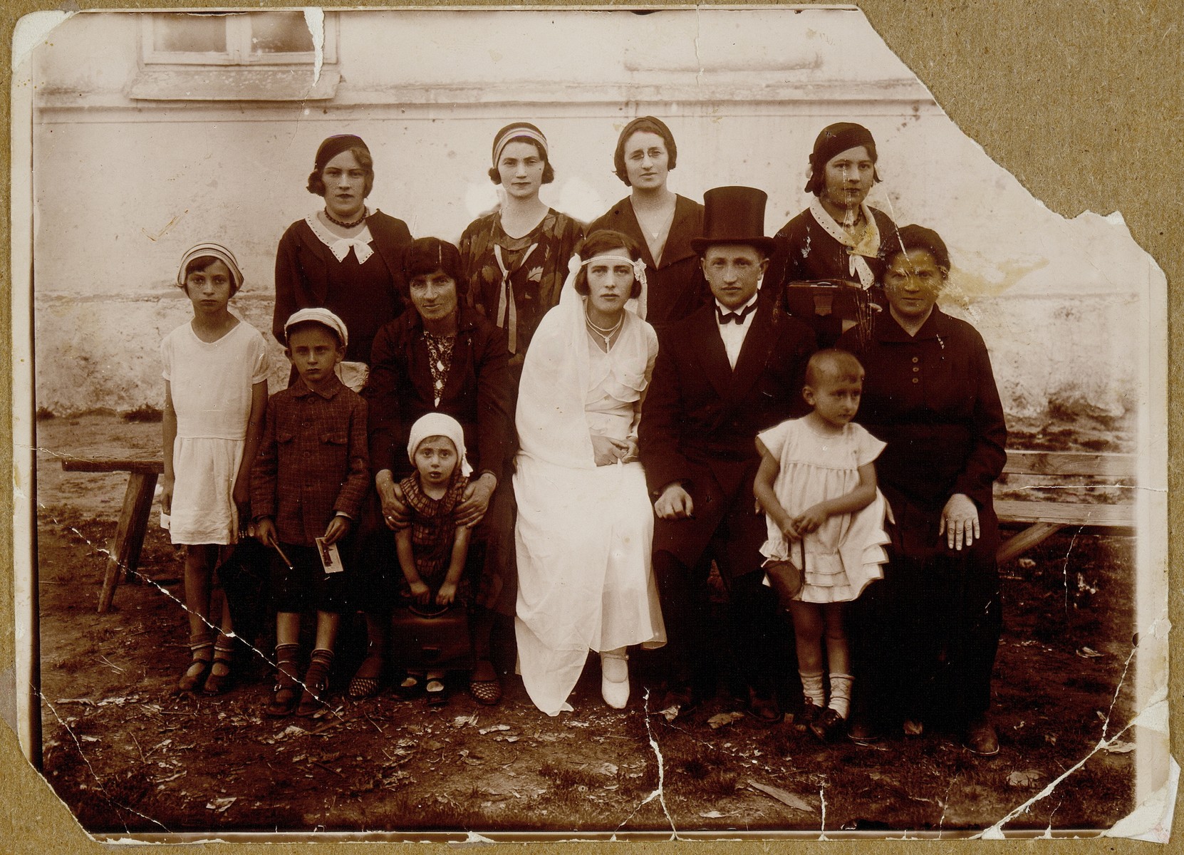 The wedding of Bat-Sheva Rozowski and Rabbi David Zalmanovitz from Ilya.  

Bat-Sheva was the daughter of Rabbi Szymen Rozowski.  This was the last wedding celebration in which the entire shtetl participated, as in pre-World War I days.  Sitting next to Bat-Sheva in the shulhoyf is her mother, Rebbetzin Miriam; next to the groom is his mother, Dvorah.  Standing behind them are Bat-Sheva's brother's wife and David's sisters.  In the front row are their little nephews and nieces.  They were all murdered during the Holocaust, the Rozowski family in the September 1941 massacre, Bat-Sheva, David, and their three children in Treblinka.