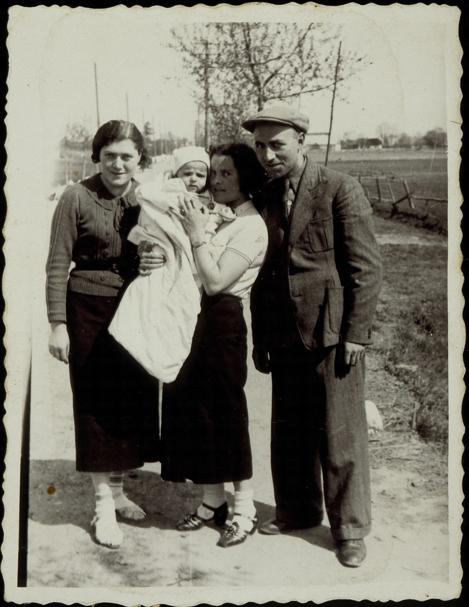 Standing from right to left: Yehudah Gaikowski, his wife, Beila Portnoy Gaikowski holding their son Yitzhak'l and Hannah Dubczanski. 

The photo is inscribed in Yiddish, "For eternal memory for my beloved brother-in-law and sister-in-law from Yehudah, Beila, Yitzhak'l Gaikowski. 1938"  The Gaikowski family and Hannah Dubczanski were murdered by the Germans during the September 1941 mass killing action in Eisiskes.