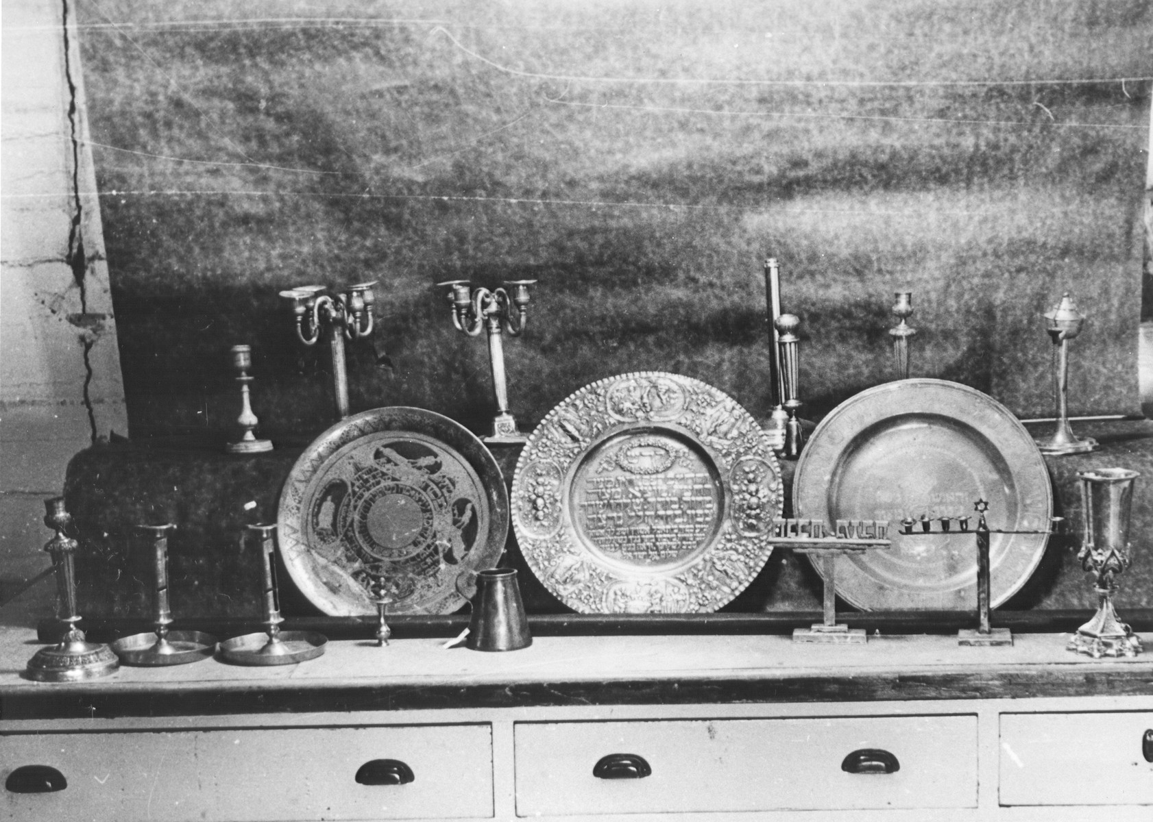 Display of silver Hannukah menorahs, Sabbath candlesticks and seder plates confiscated by the Nazis.