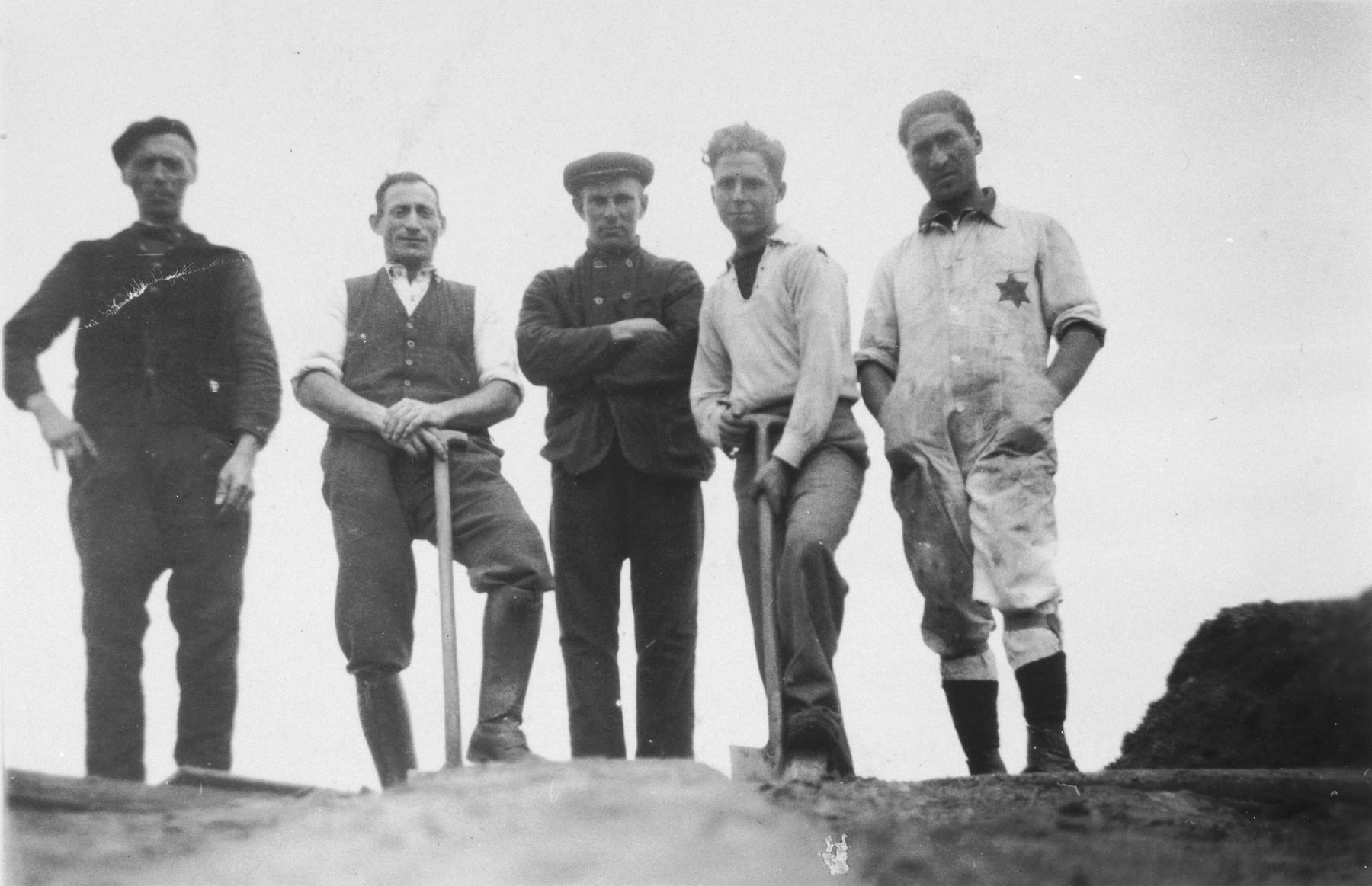 Group portrait of two Dutch Jews and three paid Dutch workers in the Staphorst-Rouveen labor camp.

Coenraad Rood, the donor, is standing first from right and Moses Cohen is second from left.