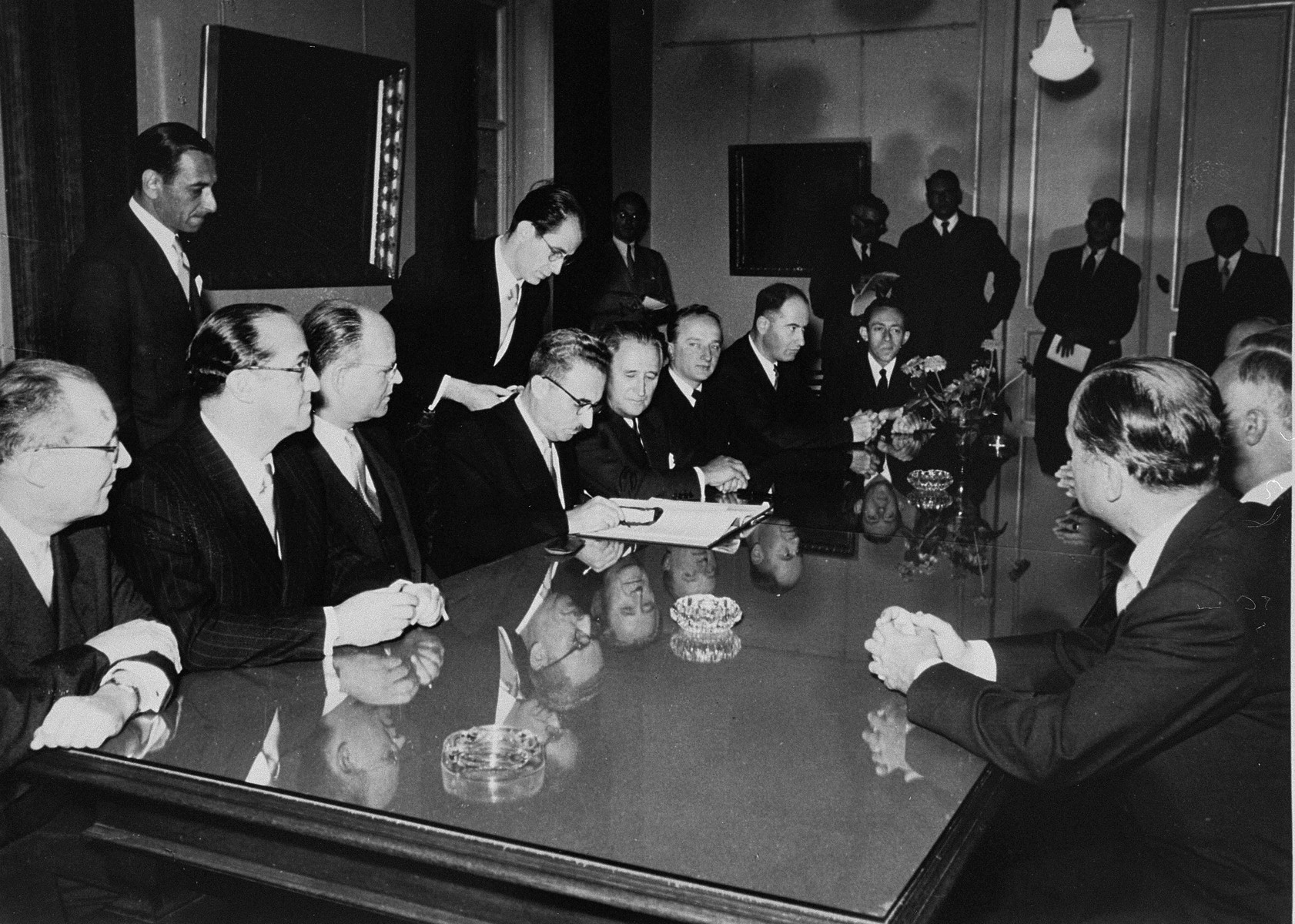 The signing of the Reparations Agreement between the German Federal Republic, the State of Israel, and the Conference on Jewish Material Claims.  

Seated from left to right are: unknown, Felix Shinnar, Giora Josephthal, Moshe Sharett, Nahum Goldmann, and Benjamin Ferencz.
