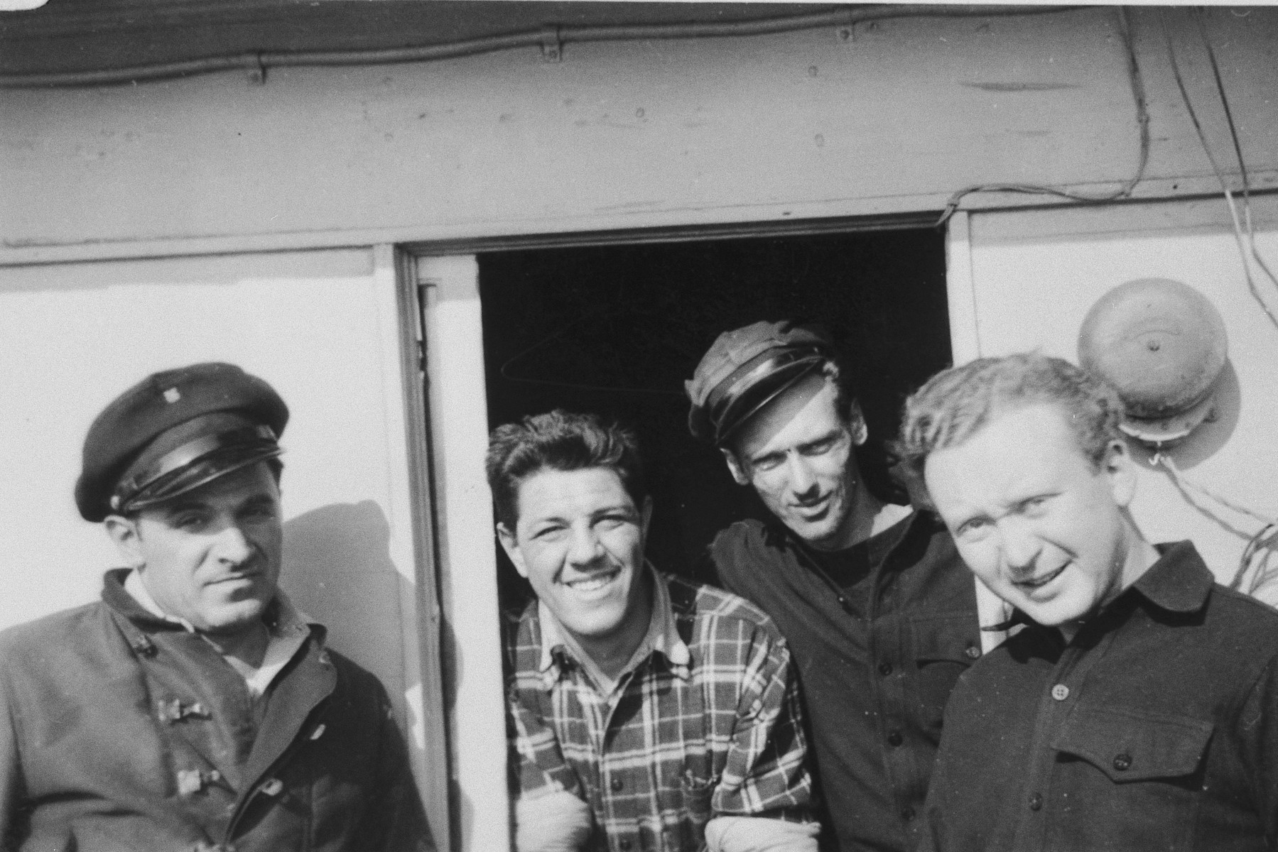 Four crew members of the President Warfield (later the Exodus 1947) pose on the deck of the ship in Baltimore harbor.

Pictured from left to right are: Mike Weiss, William Millman, Paul Yarin and William Bernstein.