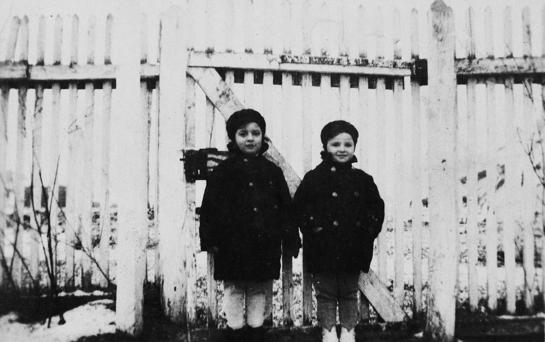 Agnes and Zsuzsi Laszlo stand together next to a wooden fence in their small farming community of Pogony Puszta.