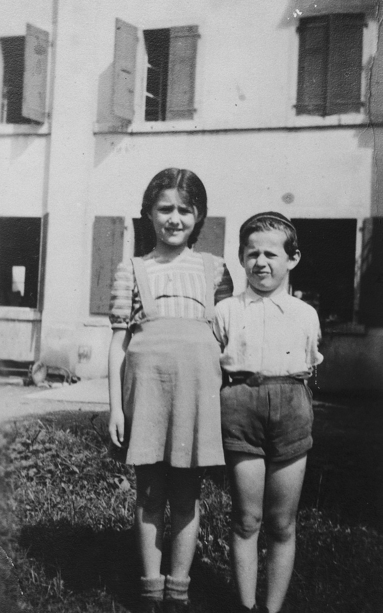 Two Jewish refugee children from Antwerp, Belgium, pose outside their children's home in Bex-les-Bains where they stayed after fleeing to Switzerland.

Pictured are Markus and Annie Wajsfeld.