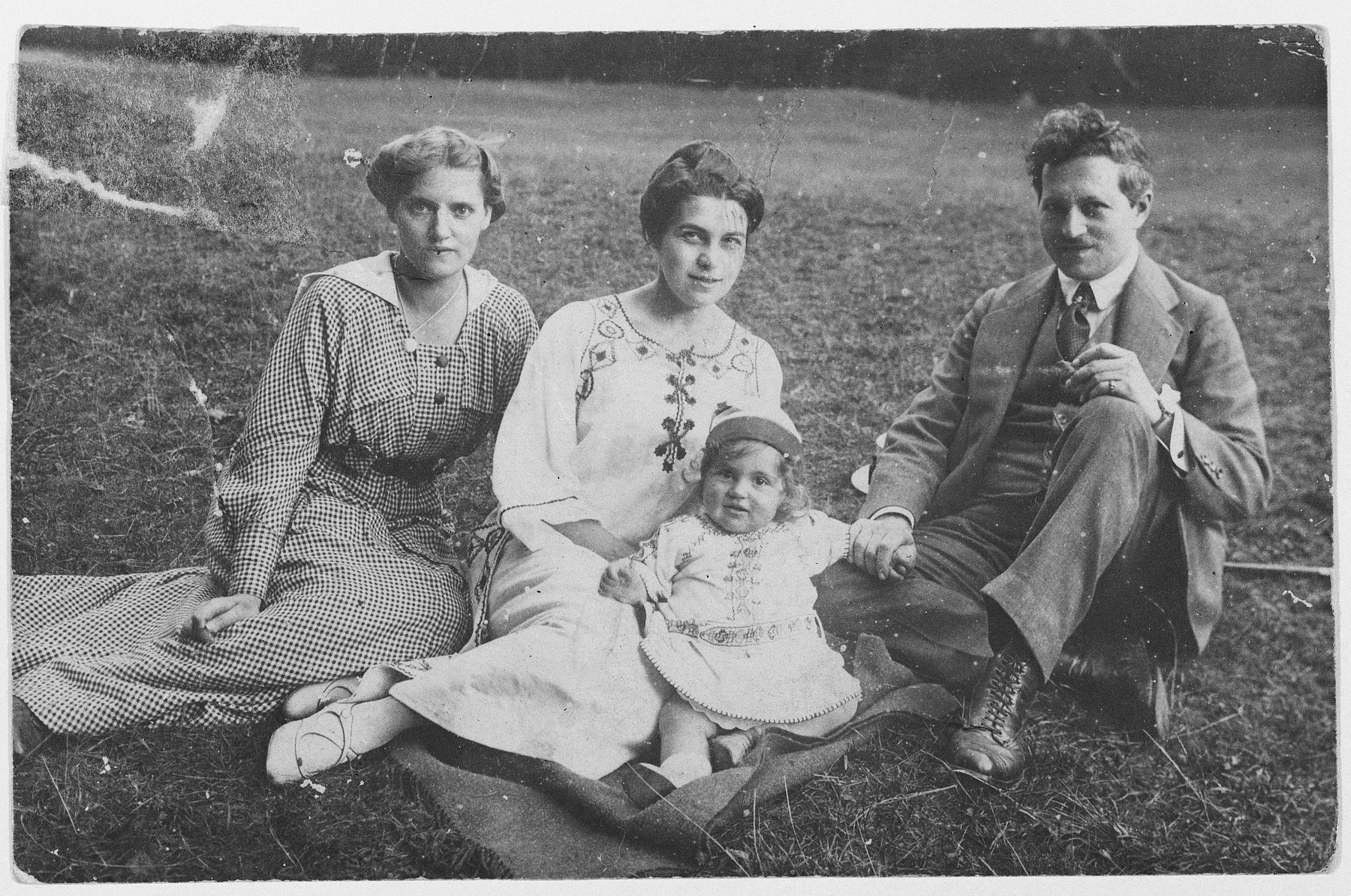 The Singer family poses for a portrait on a grassy field.

Pictured are a nanny, Gertrude, Margot and Kurt Singer.