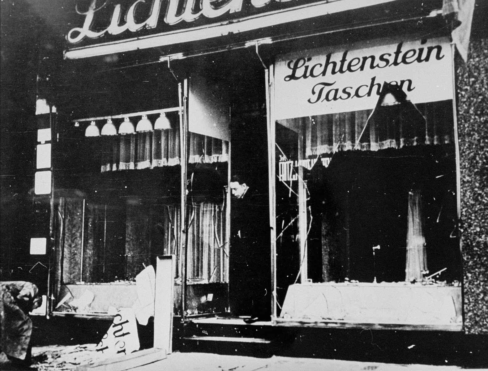 A man surveys the damage to the Lichtenstein leather goods store after the Kristallnacht pogrom.

Pictured is Fritz Lichtenstein.  The shop also sold umbrellas, which were manufactured in a small factory in Berlin  called "Lichtenstein Umbrellas." In the thirties, Fritz and his brother Hans ran the factory and this shop, together with five other shops.