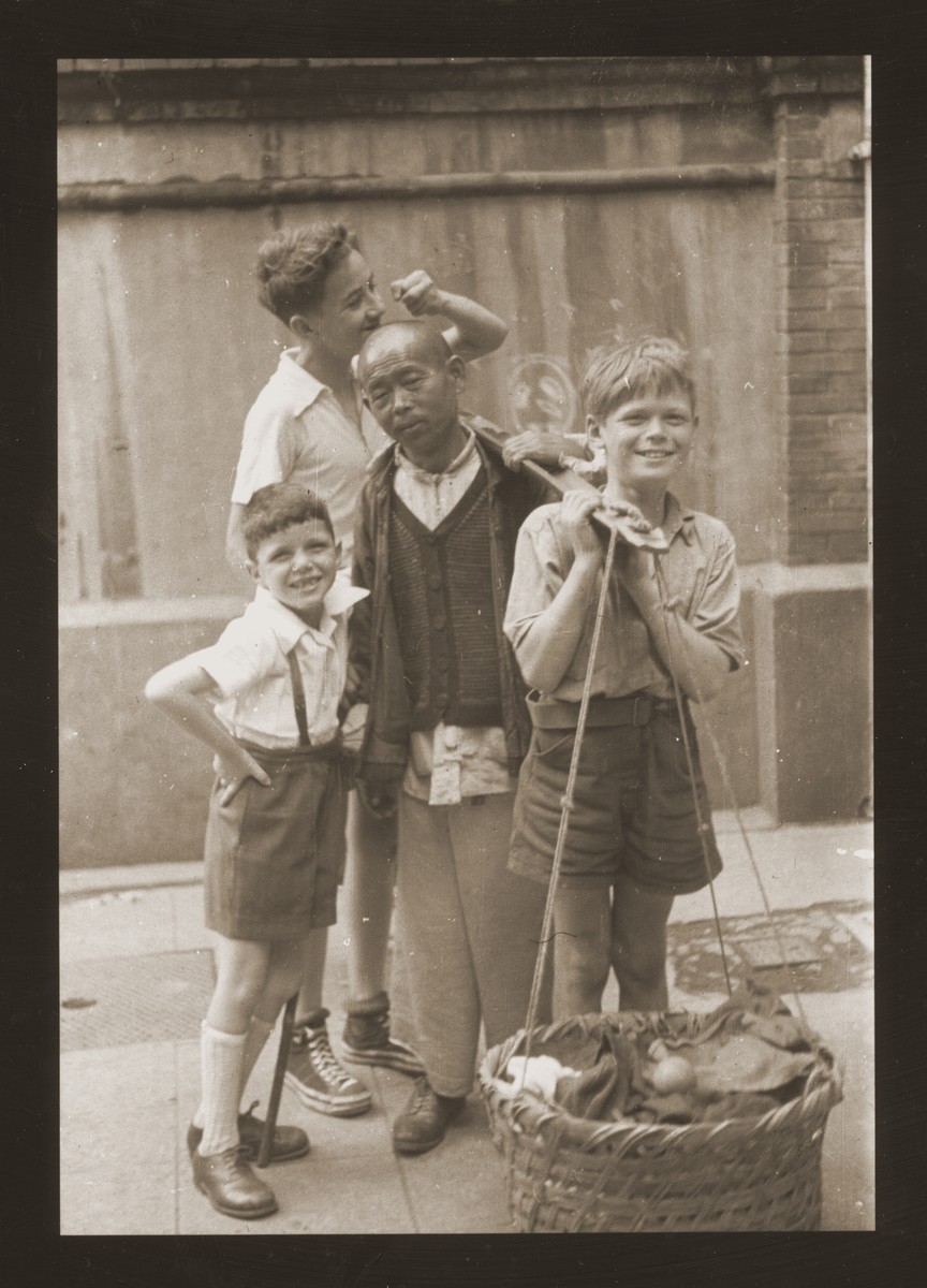 A Chinese street peddler stands with three Jewish refugee boys.  Harry Fiedler is on the far left.