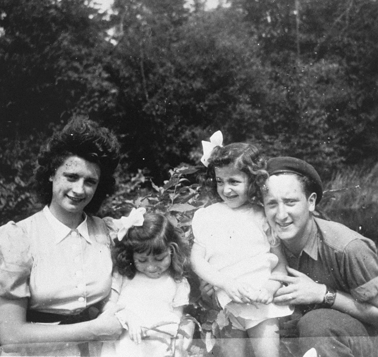 Annette and Margo Lederman, two Jewish children in hiding, pose with the daughter of their rescuers, Lydia van Buggenhout, and an allied soldier in Rumst, Belgium.