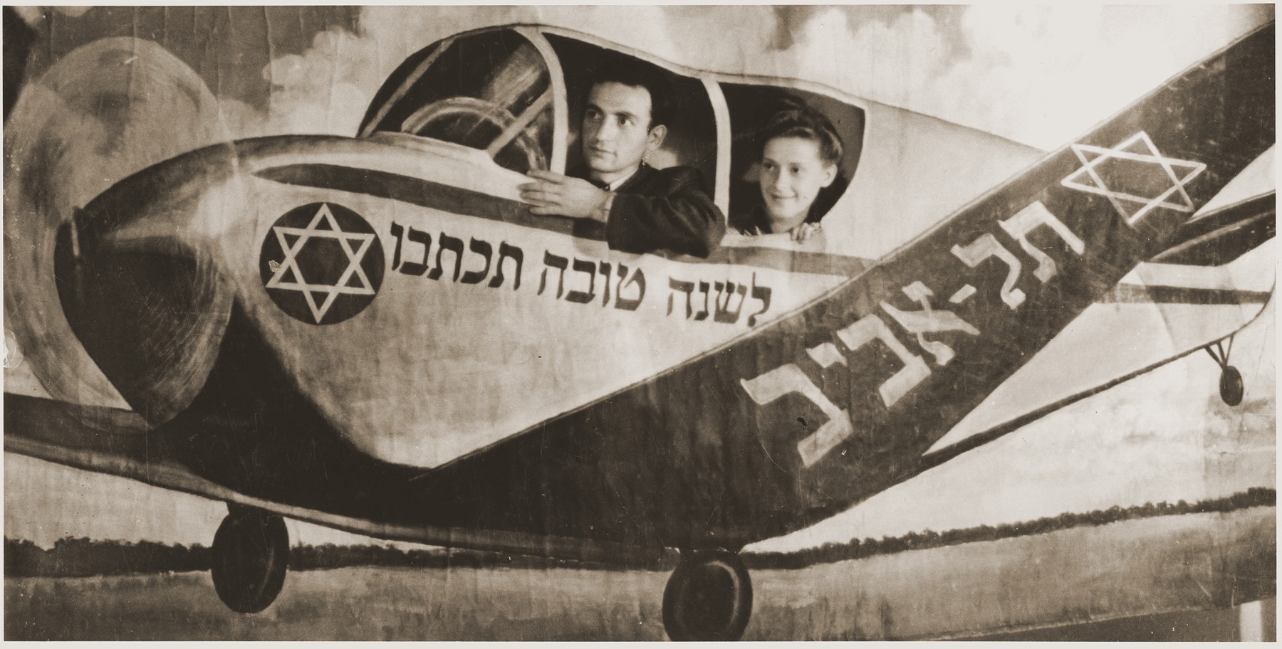A Jewish New Year's card featuring a young couple from the Fuerth displaced persons camp in an airplane bound for Tel Aviv.