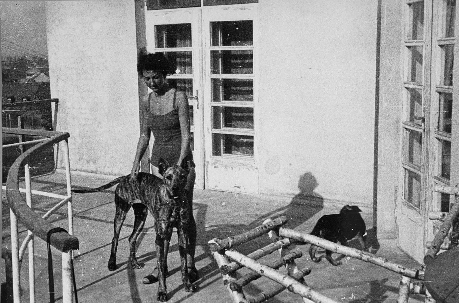 Majola, the mistress of commandant Amon Goeth, stands on the balcony of his villa in the Plaszow concentration camp with his dog Ralf.