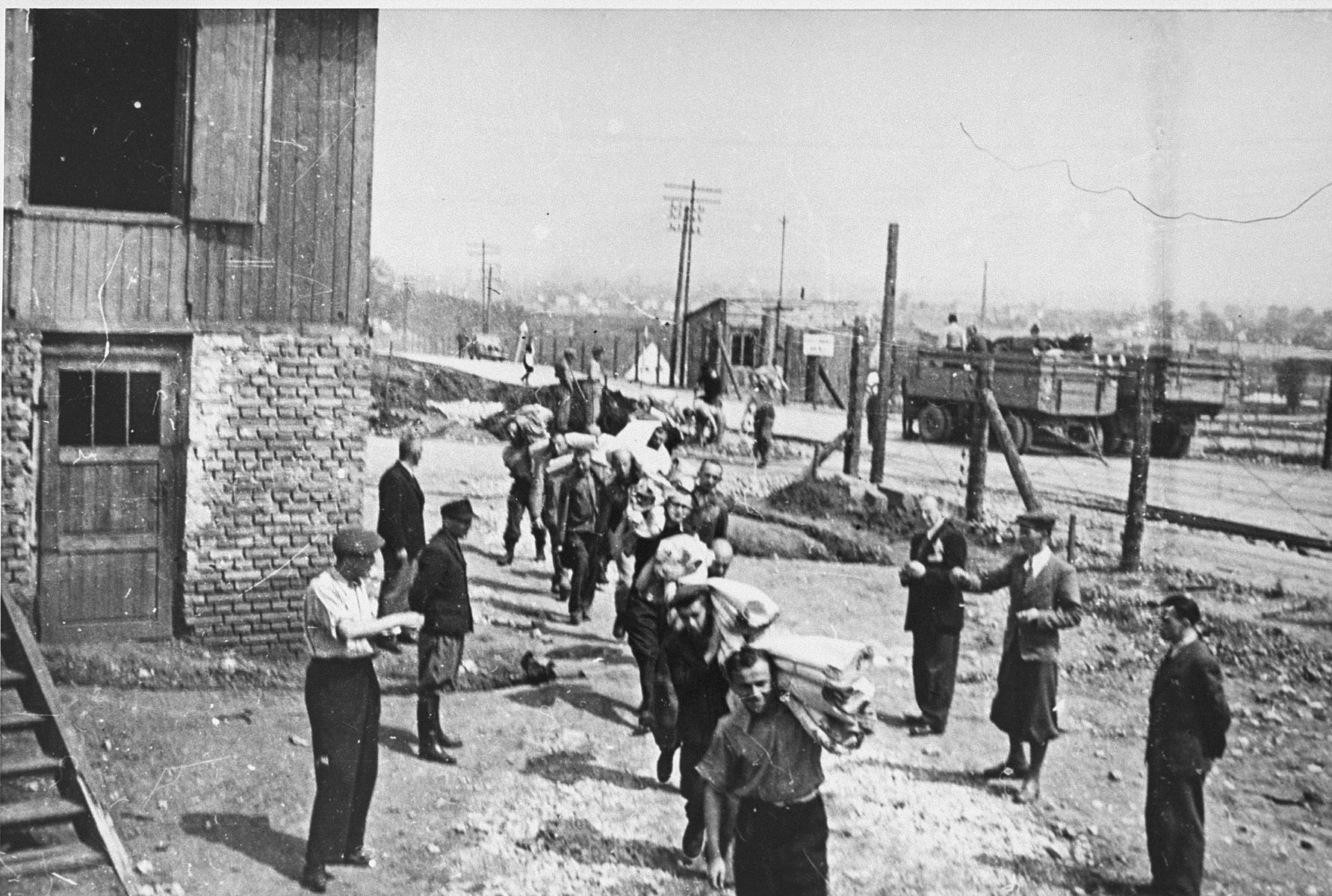 Jewish prisoners carry bolts of cloth to the Madritch factory in Plaszow.  The Madritch factory utilized concentration camp labor to produce uniforms for the German army.