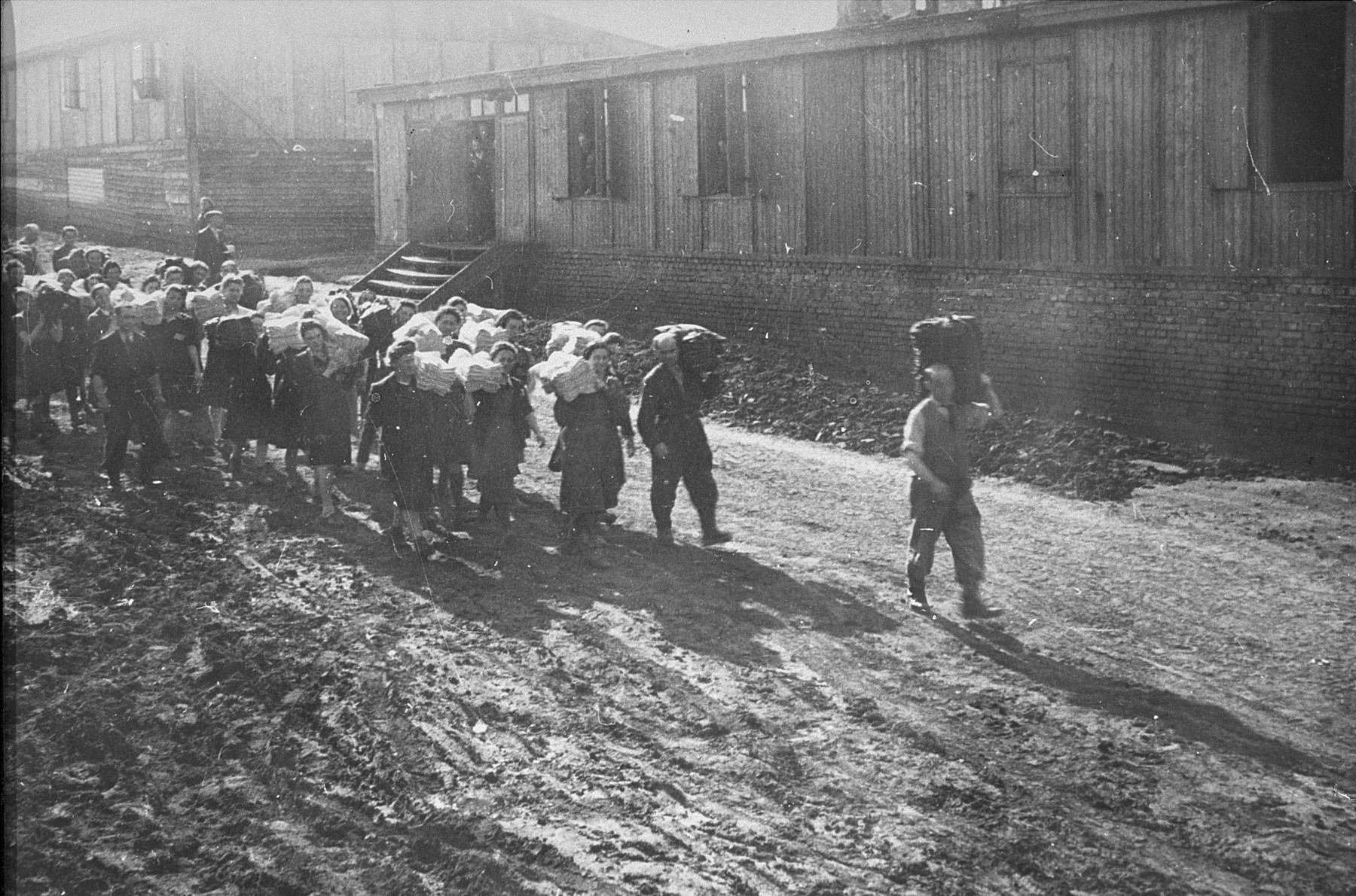 Jewish prisoners carry cloth to the Madritch factory.  The Madritch factory utilized concentration camp labor to produce uniforms for the German army.