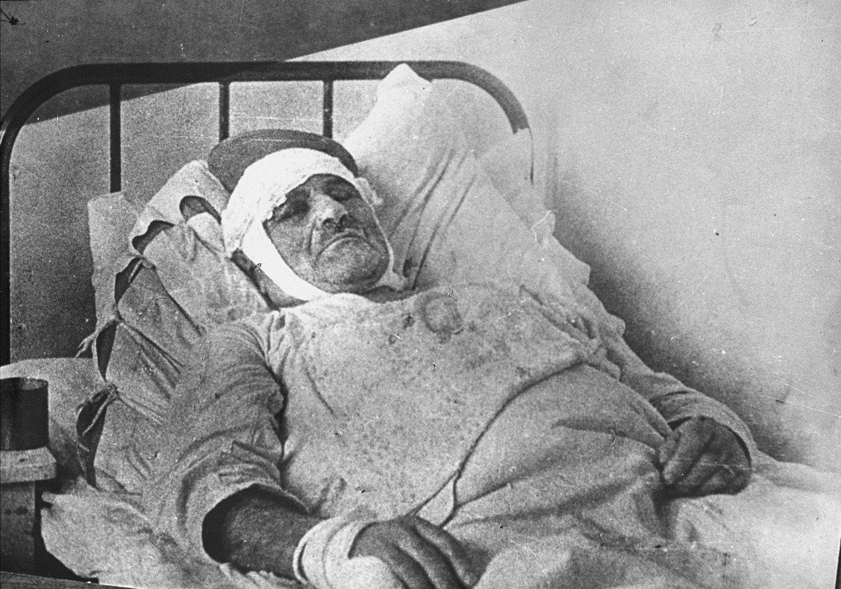 A Jewish man injured in the Kielce pogrom lies in a hospital bed.