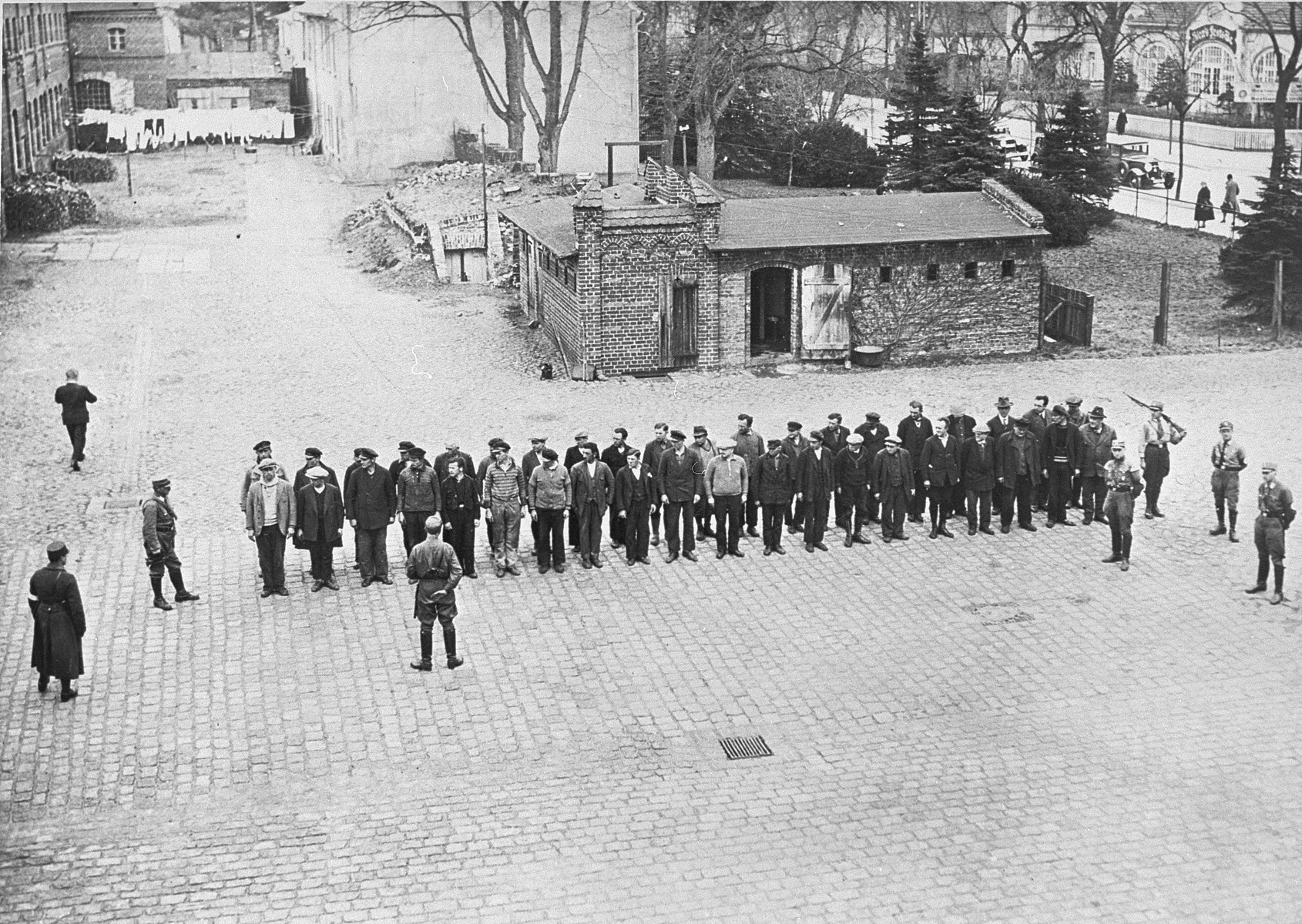 Prisoners guarded by SA men line up in the yard of the Oranienburg concentration camp on the Havel River in Germany.