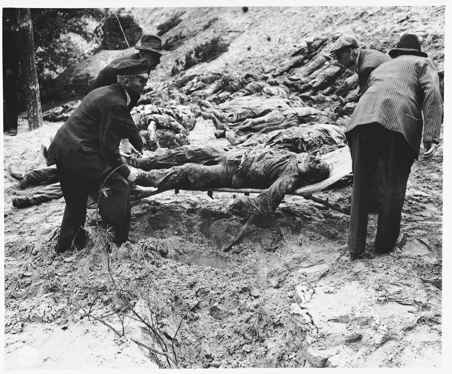 Under the supervision of American soldiers, German civilians exhume the bodies of 71 political prisoners from a mass grave on Wenzelnberg near Solingen-Ohligs.  

The victims, most of whom were taken from Luettringhausen prison, were shot and buried by the Gestapo following orders to eliminate all Reich enemies just before the end of the war.