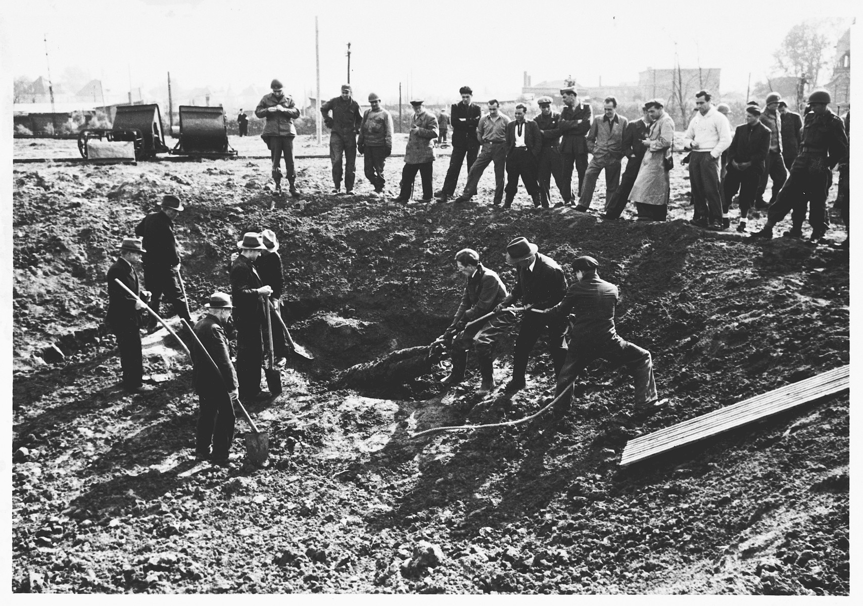 Under supervision of American soldiers, German civilians exhume the corpses of Italians shot in shell holes on the orders of the Gestapo in Wilhelmshoehe on March 31, 1945.