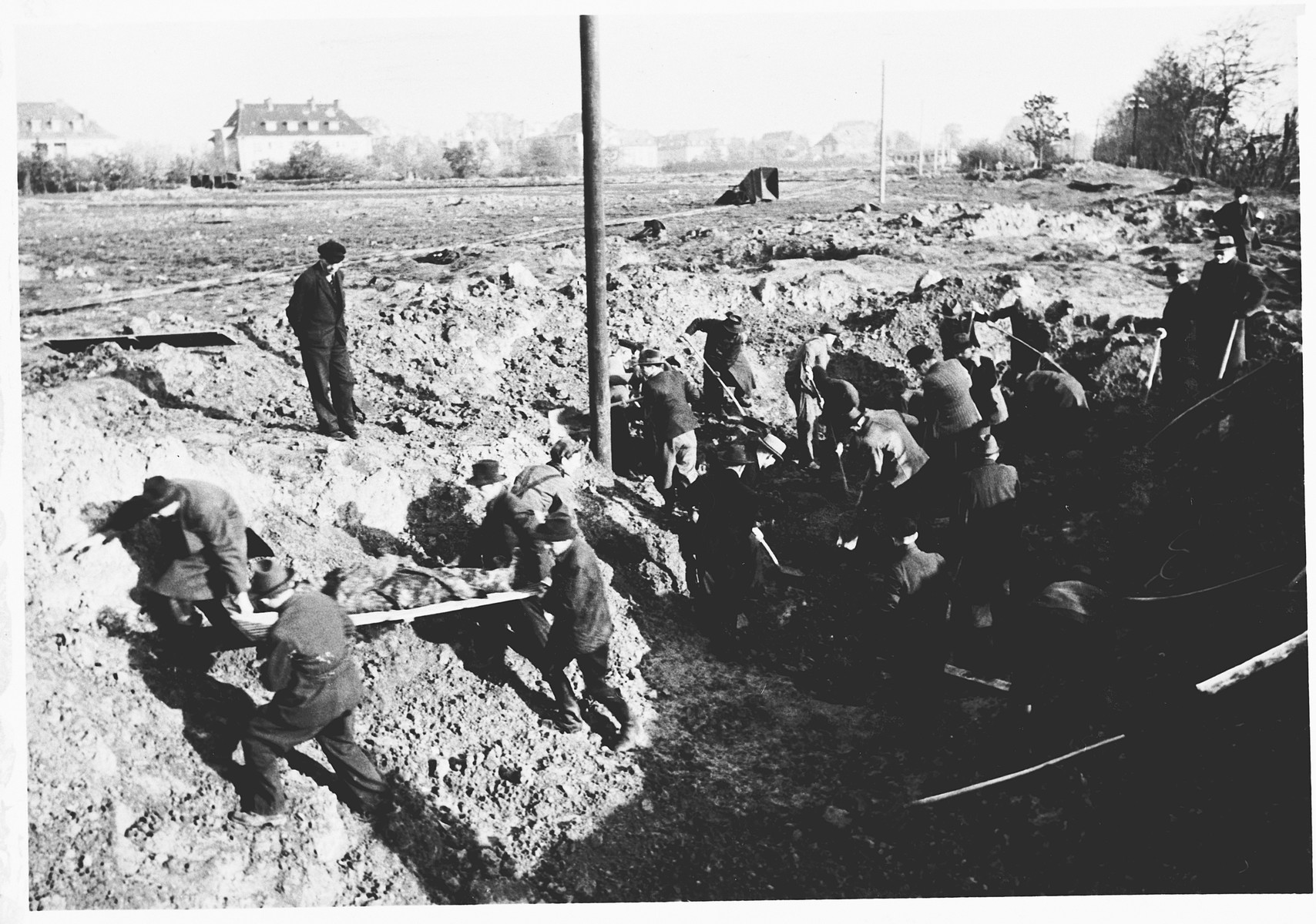 German civilians exhume the corpses of Italians shot in shell holes on the orders of the Gestapo in Wilhelmshoehe on March 31, 1945.