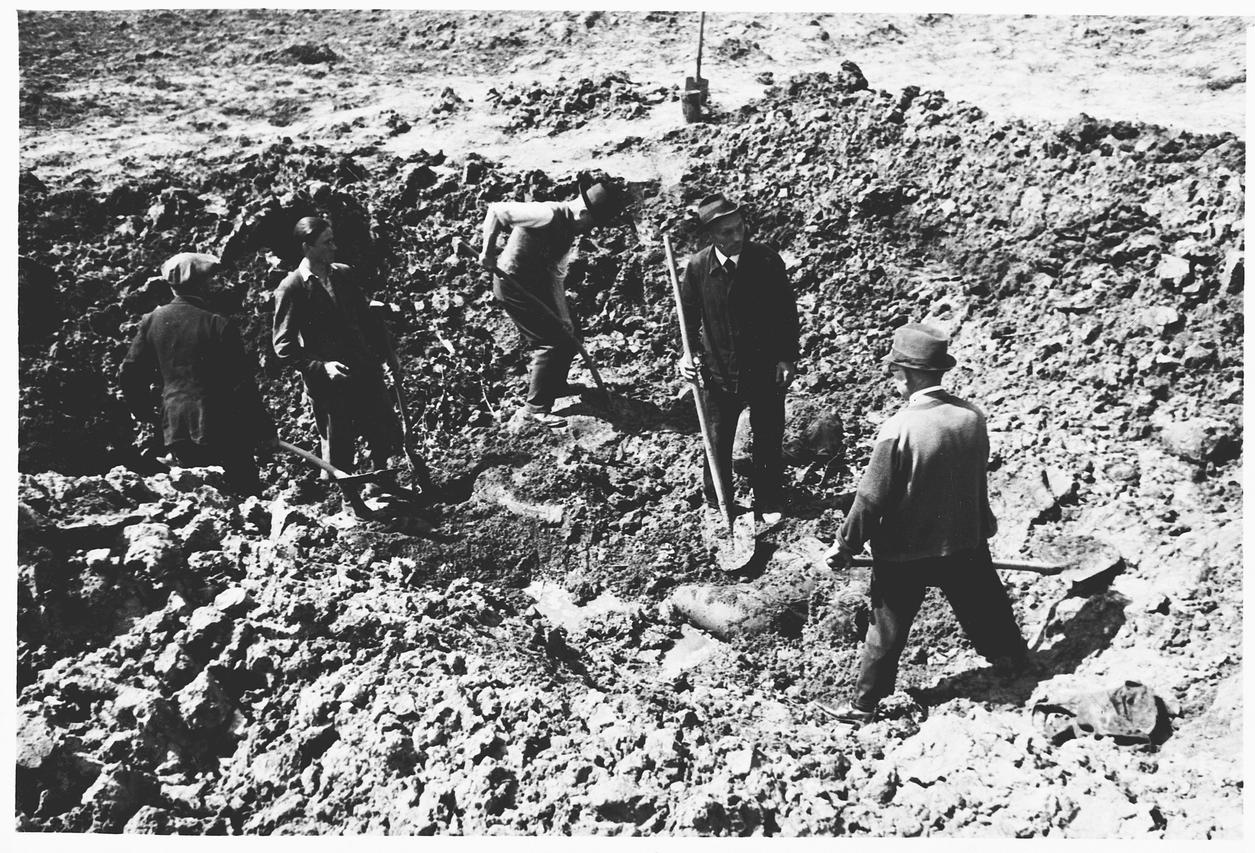 German civilians exhume the corpses of Italians shot and buried in shell holes on the orders of the Gestapo in Wilhelmshoehe on March 31, 1945.