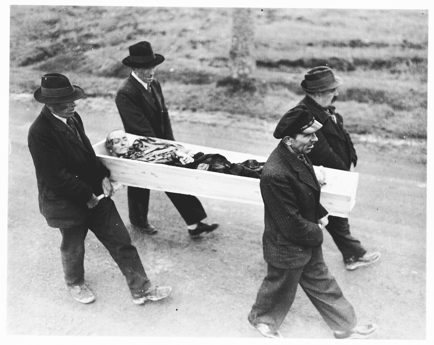 German civilians from Neunburg carry a body found in a nearby forest to the town cemetery for proper burial. 

The victim was a Jewish prisoner from Flossenbuerg shot while on a death march.