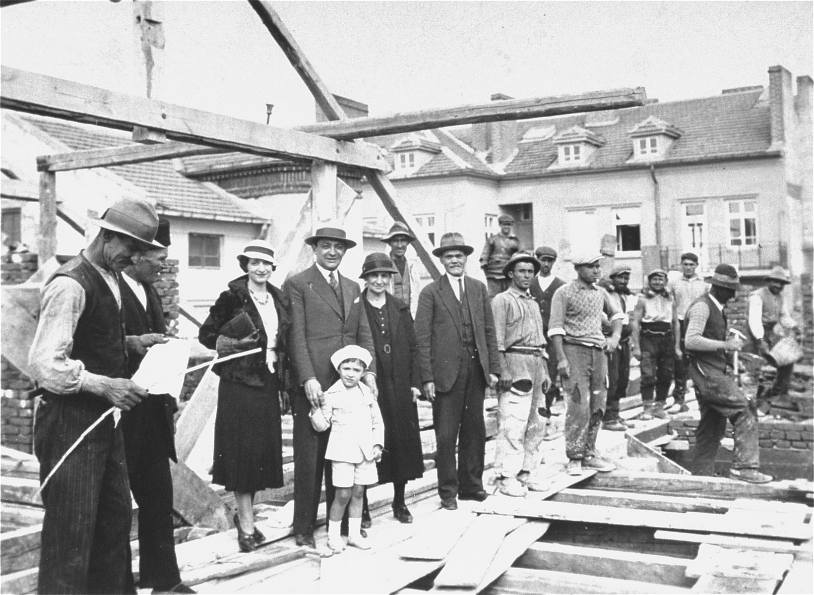 Members of the Yasharoff family pose with construction workers at the site of their new home, a three-story apartment building located at 24 Benkovska Street in Sofia.

Pictured from left to right are: two construction workers, Nelly and Joseph Yasharoff with two-year-old Norbert, Oro and Nissim Yasharoff.