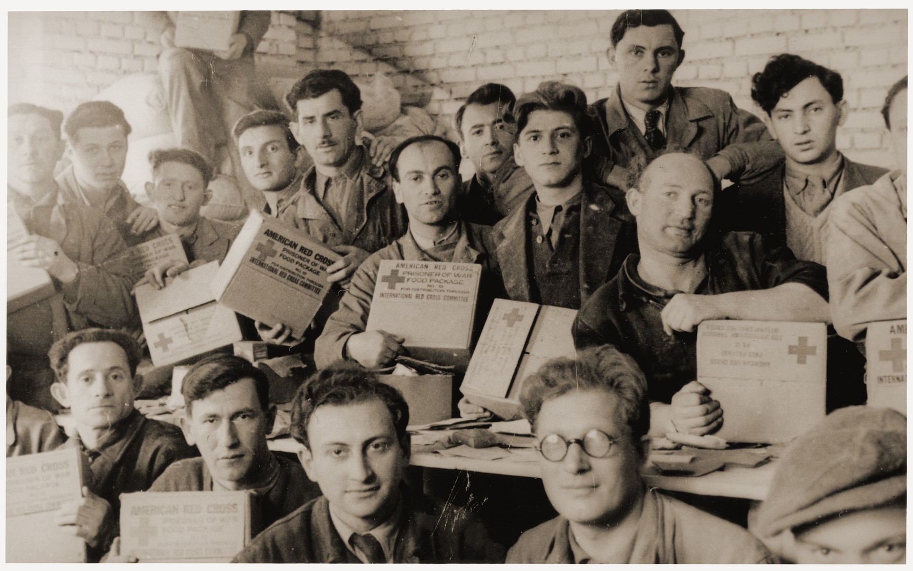 Group portrait of Jewish DPs holding American Red Cross food parcels at the Feldafing displaced persons camp.

Among those pictured is Leon Bergrin (second row, sixth from the left).