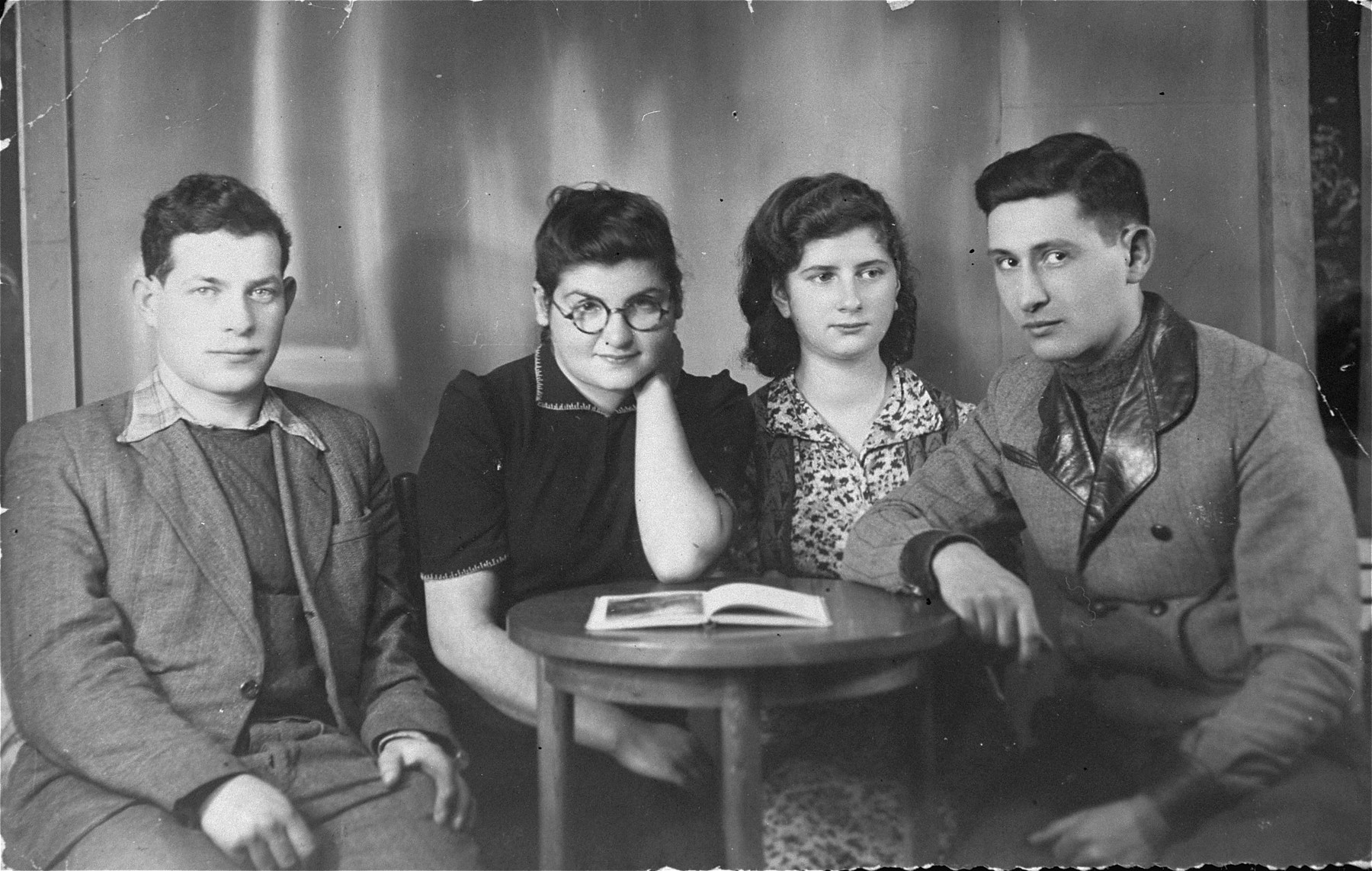 Four members of the Hashomer Hatzair Zionist collective in Zarki are seated around a table.

Pictured from left to right are: Aron Szwarc, Tamar (last name unknown), Lodzia Hamersztajn, and Berel Lemel.