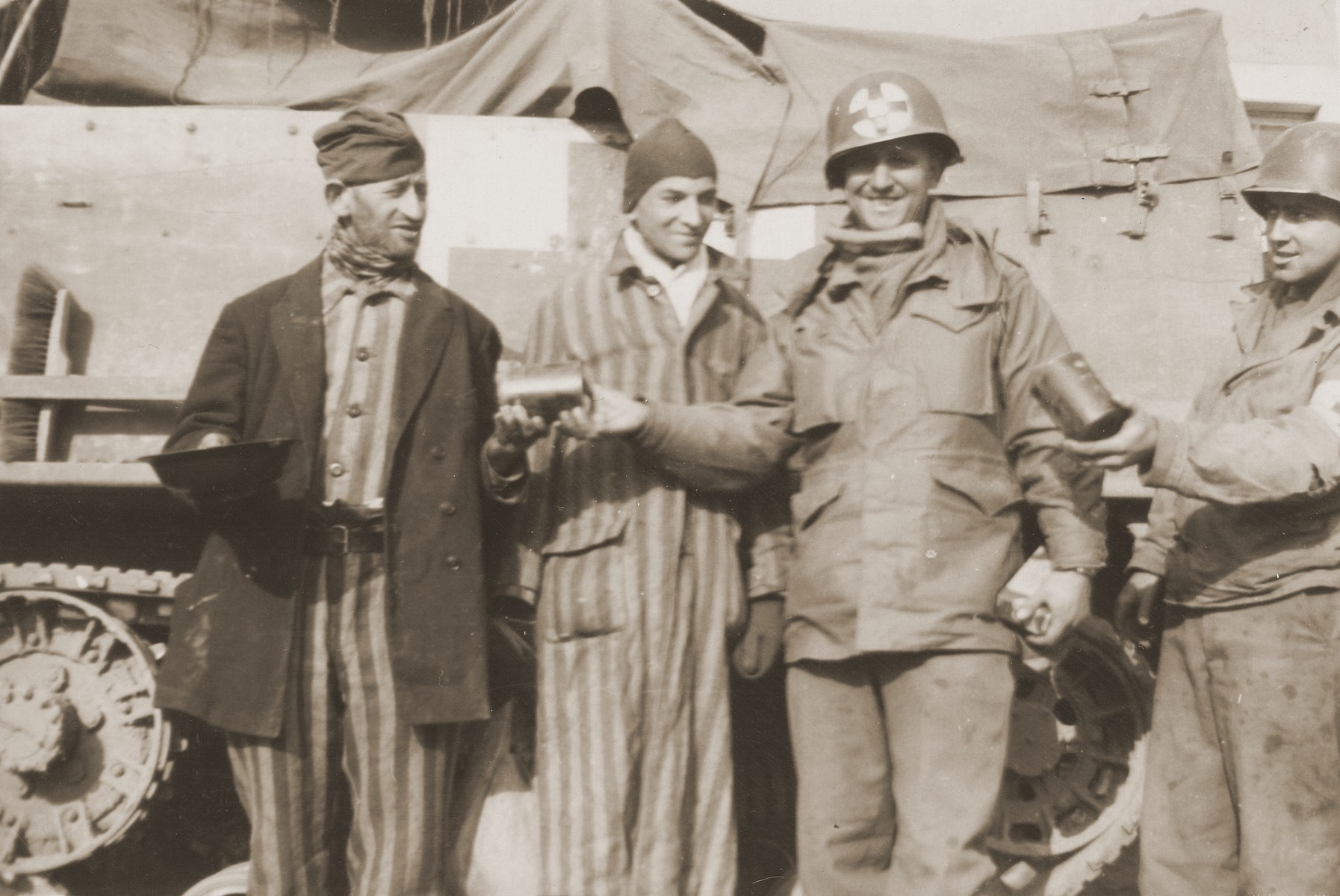 U.S. Army medical personnel with the 10th Armored Division distribute food to two survivors liberated from a concentration camp.  

The man in the center is Technical Sergeant George Delmonica.