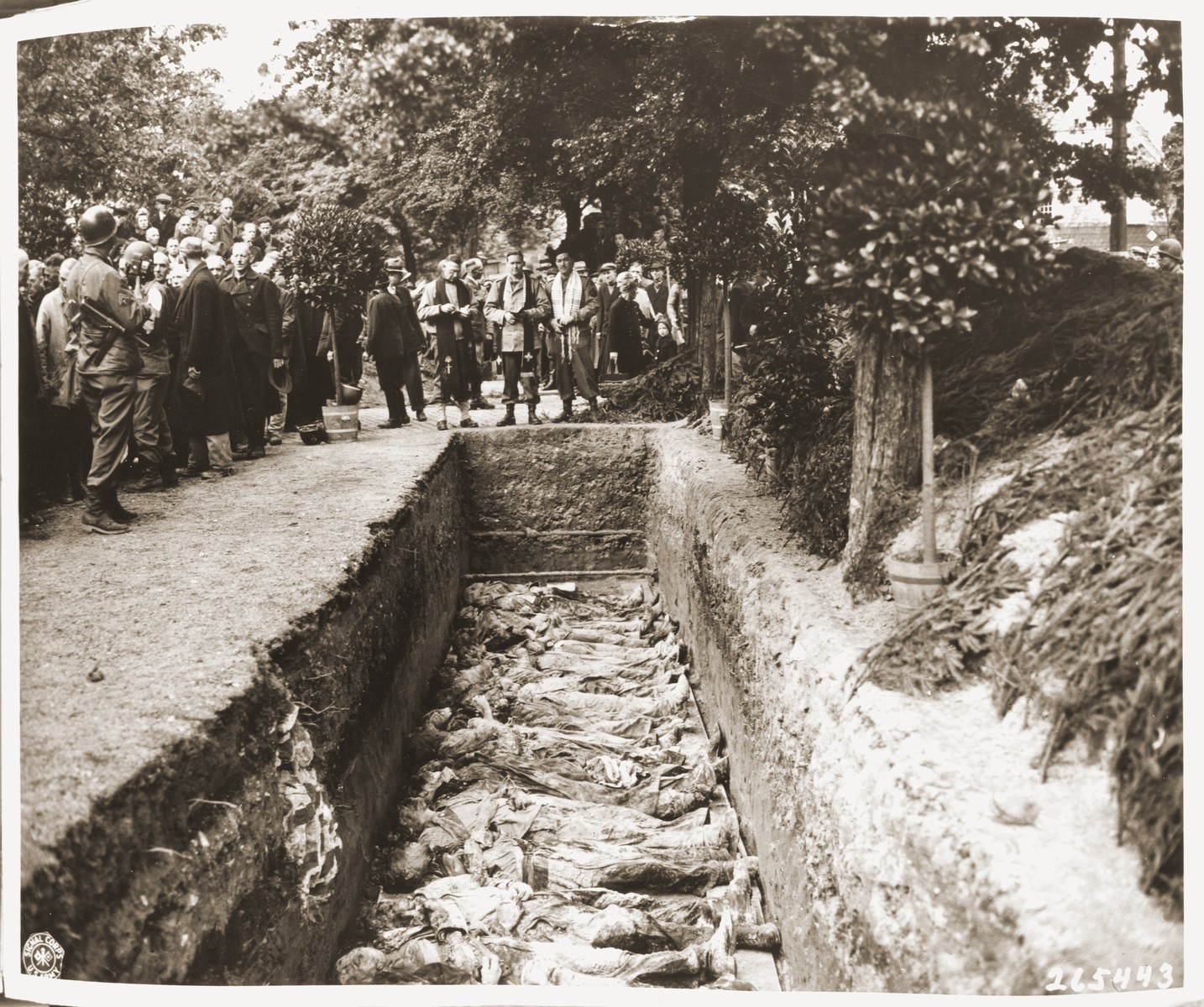 Protestant, Catholic and Jewish chaplains conduct funeral services for the reburial of 71 political prisoners, exhumed from a mass grave near Solingen-Ohligs, in front of the city hall.  

The victims, most of whom were taken from Luettringhausen prison, were shot and buried by the Gestapo following orders to eliminate all Reich enemies just before the end of the war.