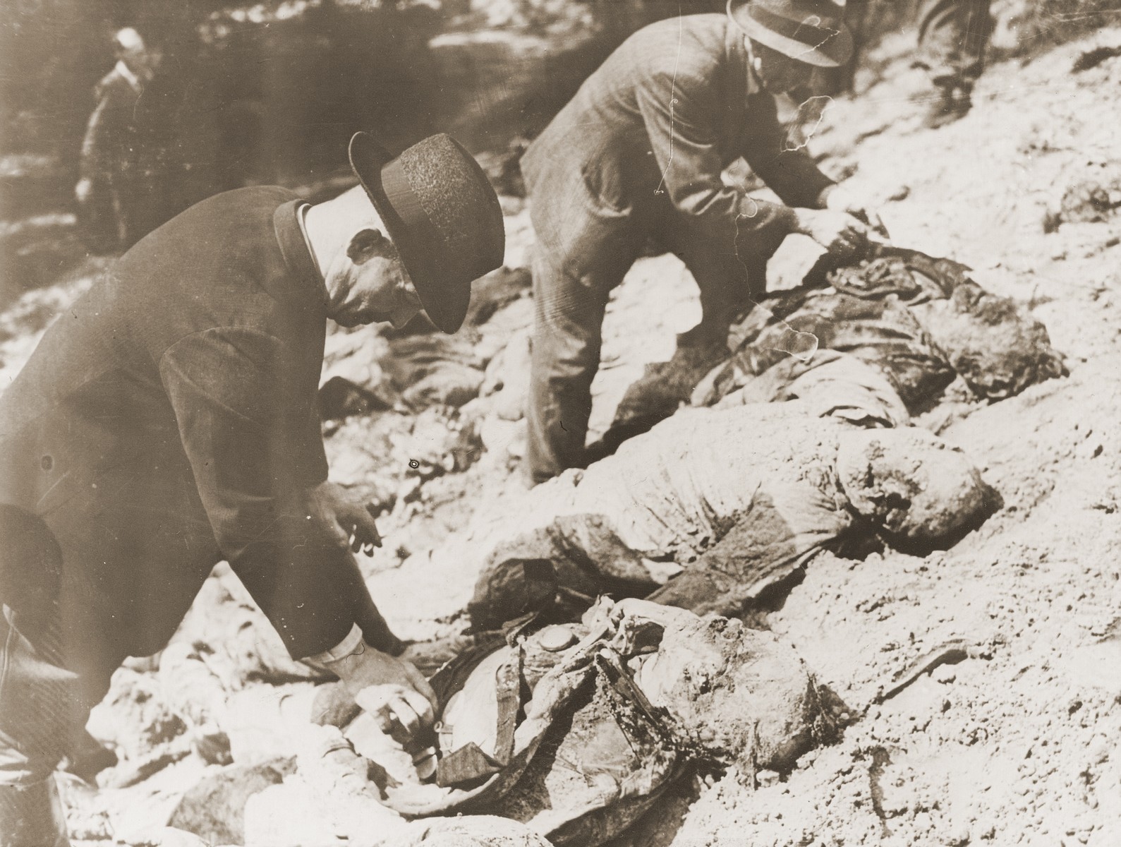 German civilians identify the bodies of 71 political prisoners exhumed from a mass grave on Wenzelnberg near Solingen-Ohligs.  

The victims, most of whom were taken from Luettringhausen prison, were shot and buried by the Gestapo following orders to eliminate all Reich enemies just before the end of the war.